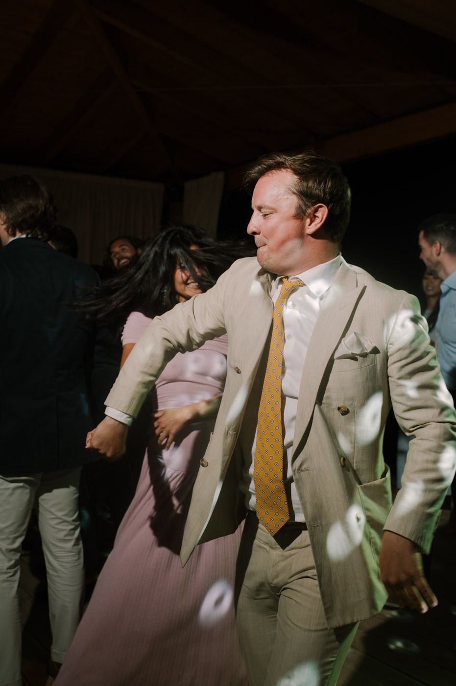 Wedding party dancing and celebrating on the dance floor in formal attire.