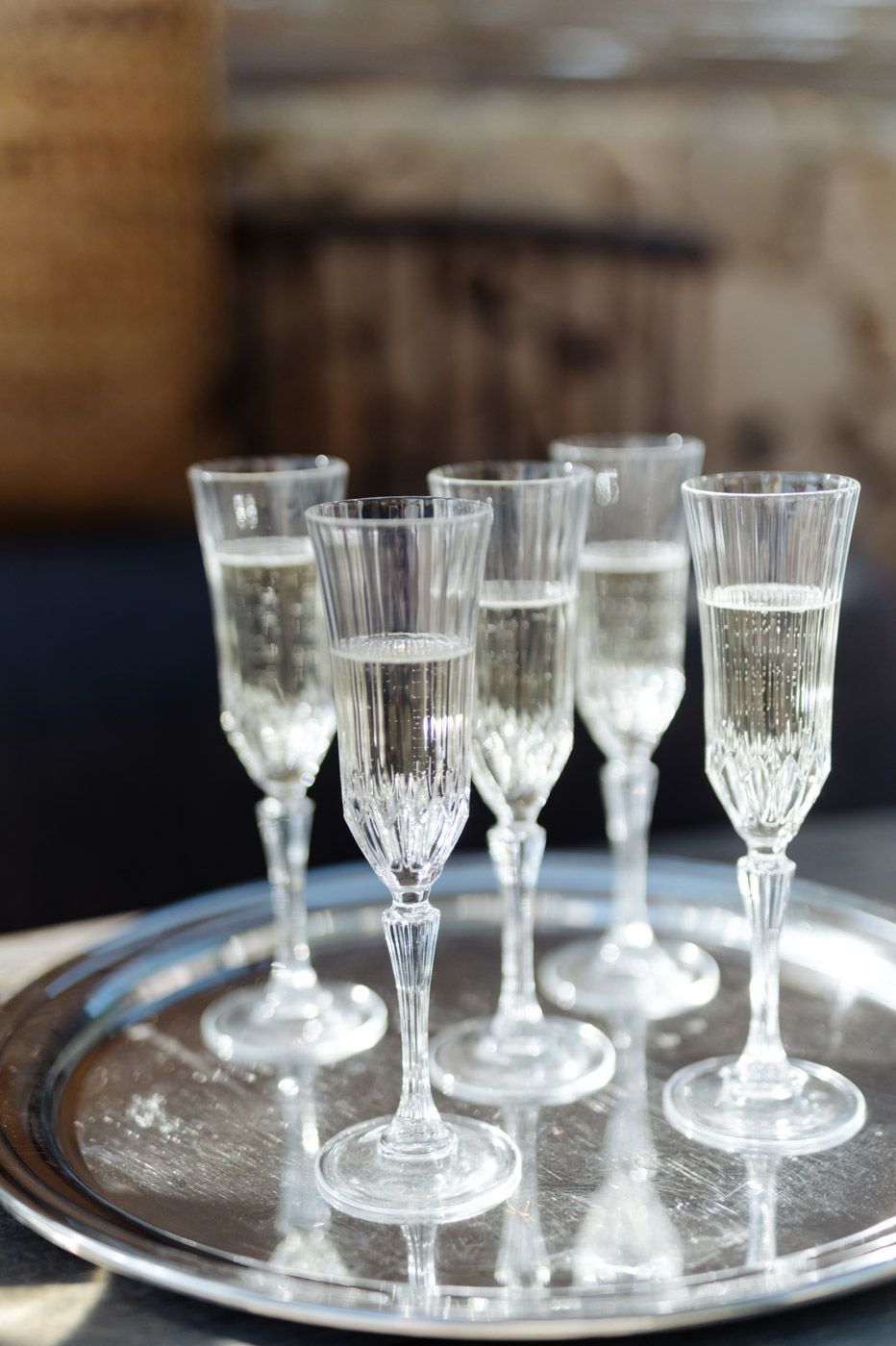 Vintage crystal champagne glasses arranged on a silver serving tray.