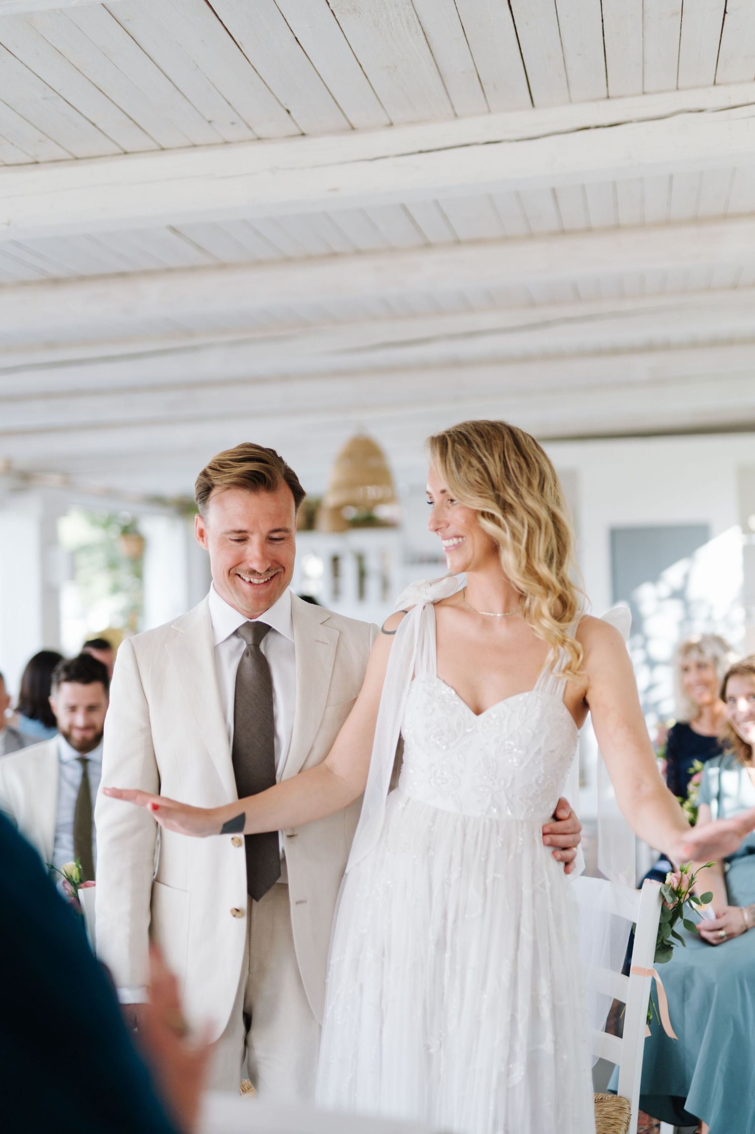 Candid moments of a wedding ceremony showing joyful interactions in a light-filled venue.