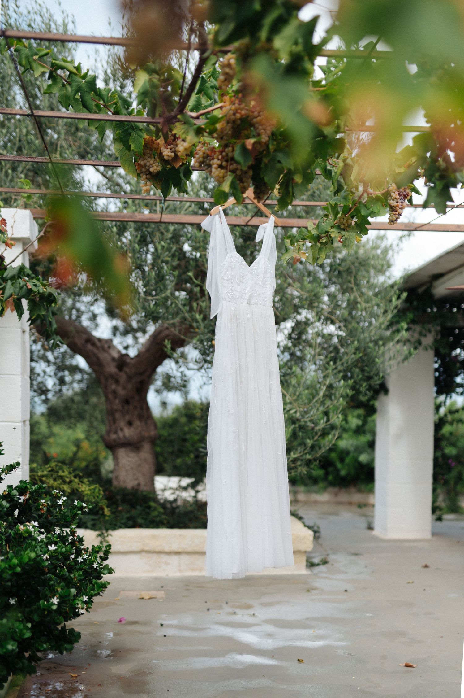 White wedding dresses displayed on outdoor clothesline against natural garden setting.