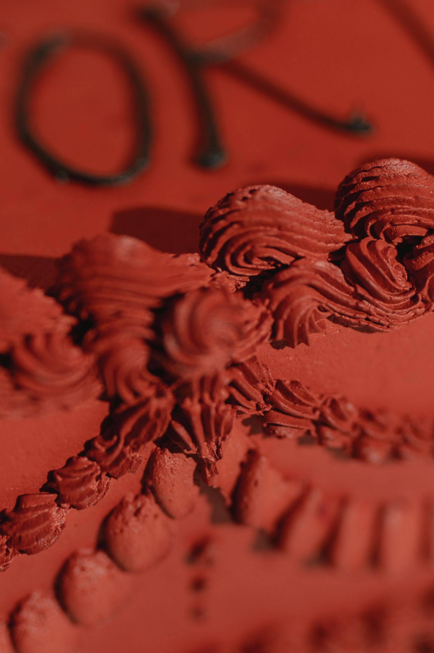Close-up macro photograph of ornate architectural molding details in deep red lighting.