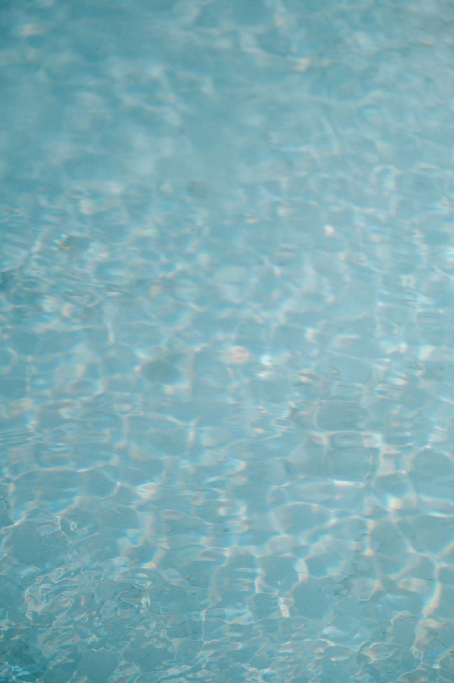 Rippling blue pool water creating abstract patterns in sunlight.