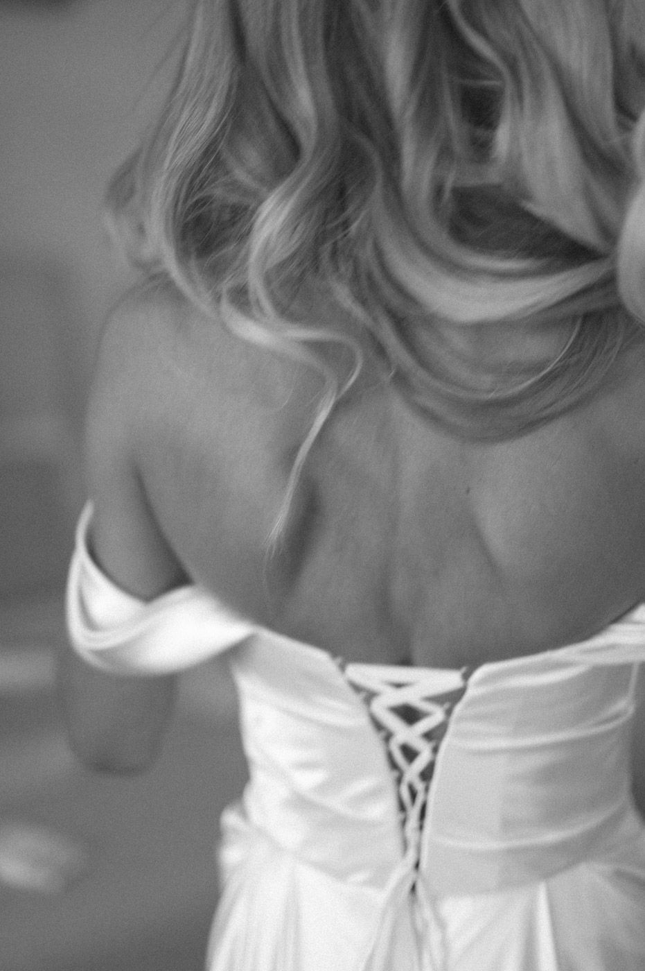Back detail of a white corset-style dress with lacing.