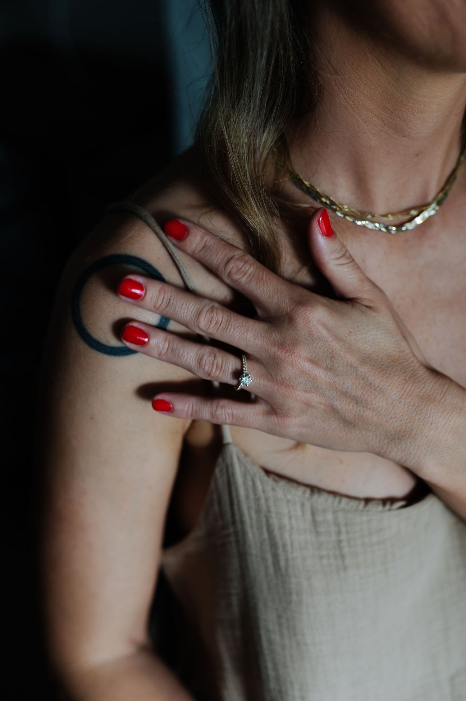 Close-up shot of hands with red nail polish against a light background.