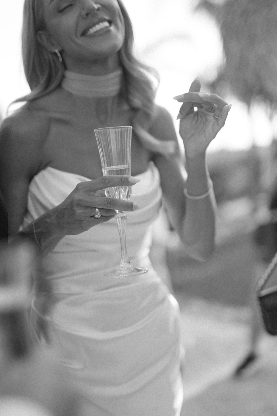 Wedding celebration with champagne glasses and white dresses in soft focus.