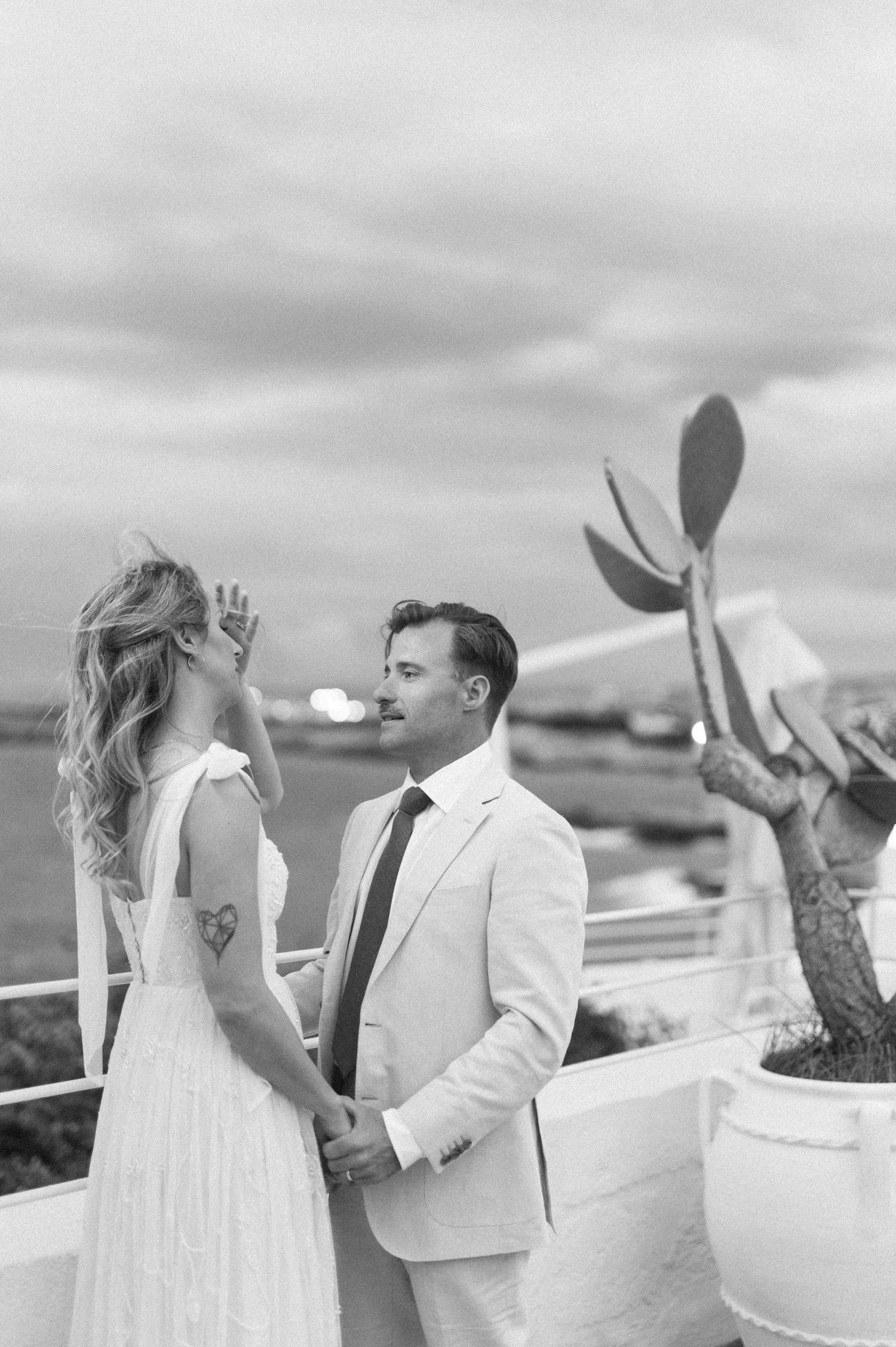 Black and white sequence of a couple dancing on a seaside terrace.