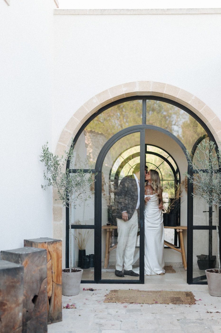 Wedding ceremony setup with elegant arched doorways and white decor.