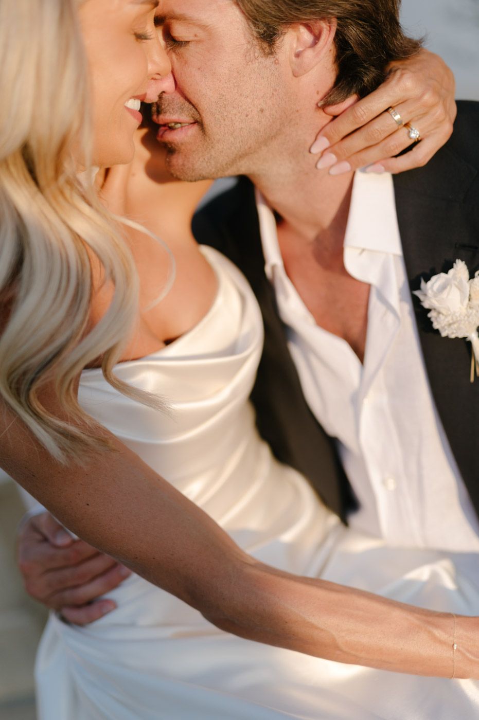A romantic series of five close-up photos showing a tender embrace and kiss between a couple in white and dark clothing.