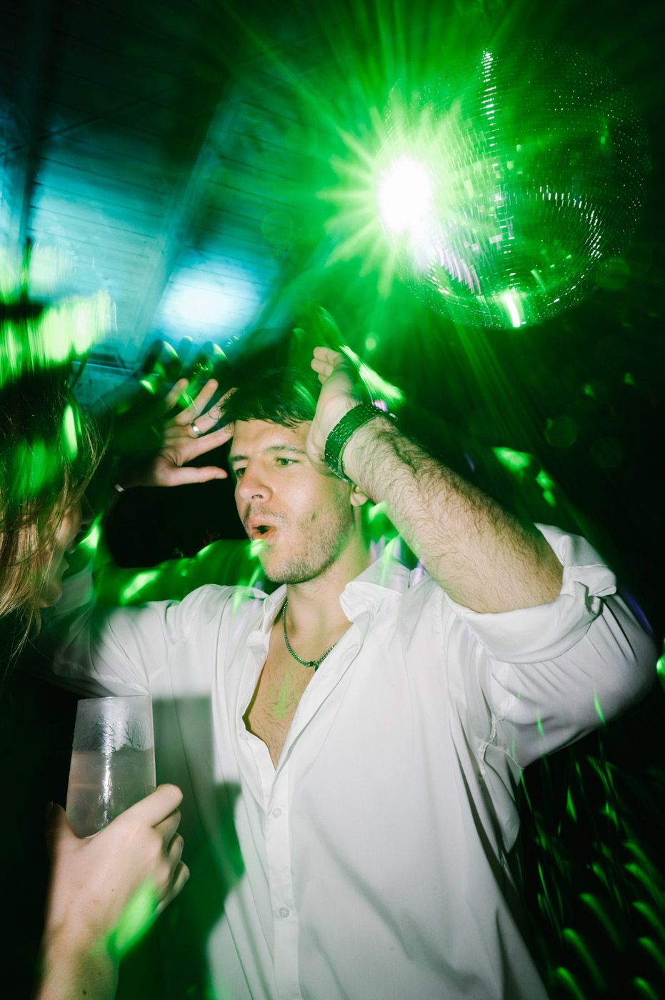 Party scene with green lighting effects and energetic dancing.