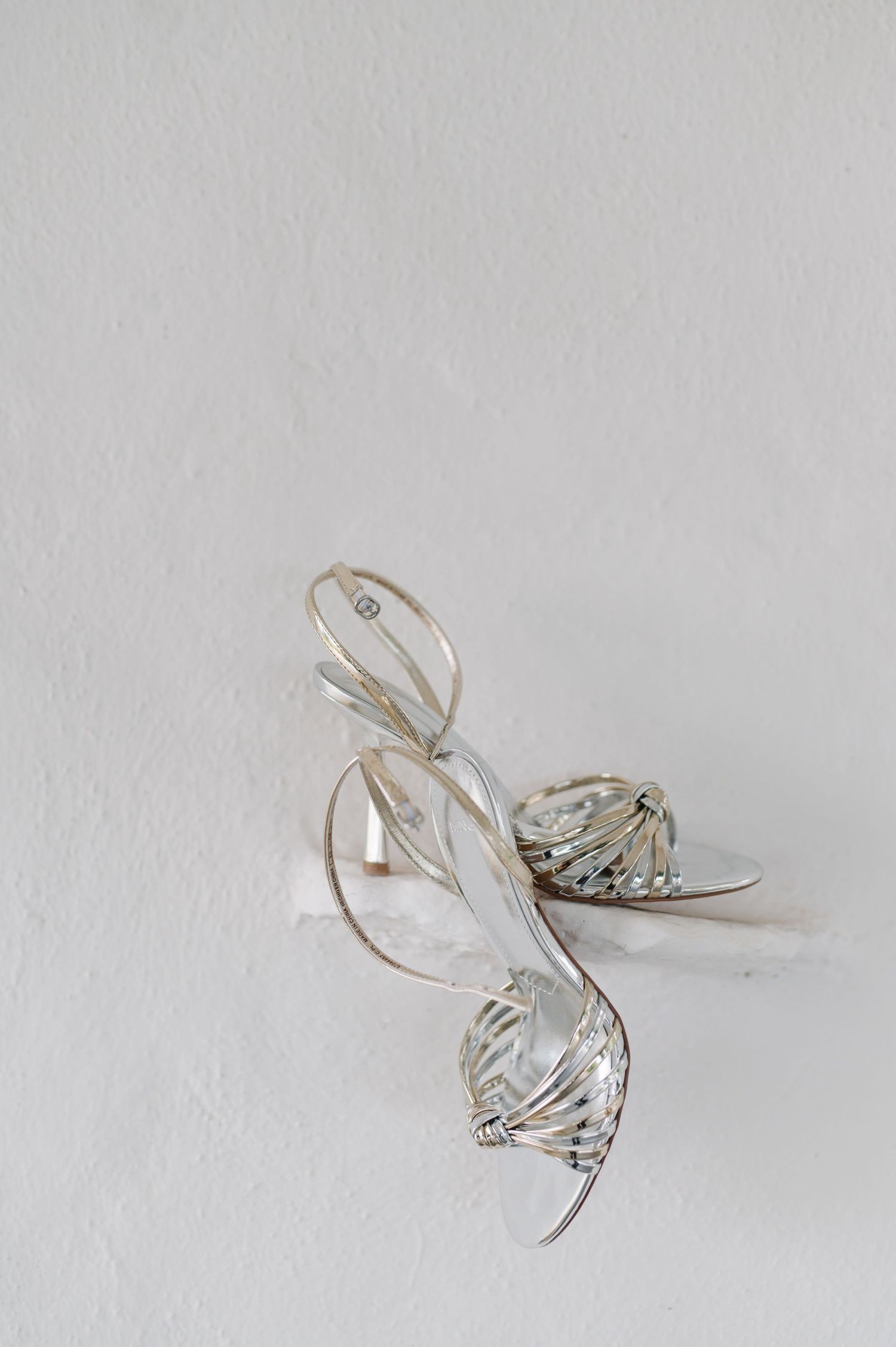 Silver wedding rings with delicate spiral design photographed on white background.
