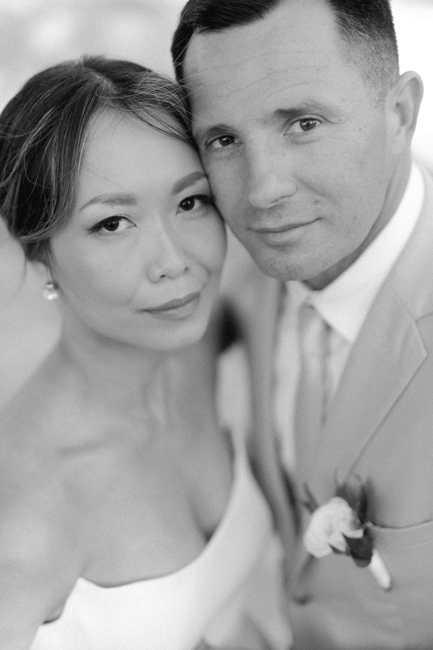 A series of black and white romantic wedding photos showing close-up portraits of a couple in formal attire.