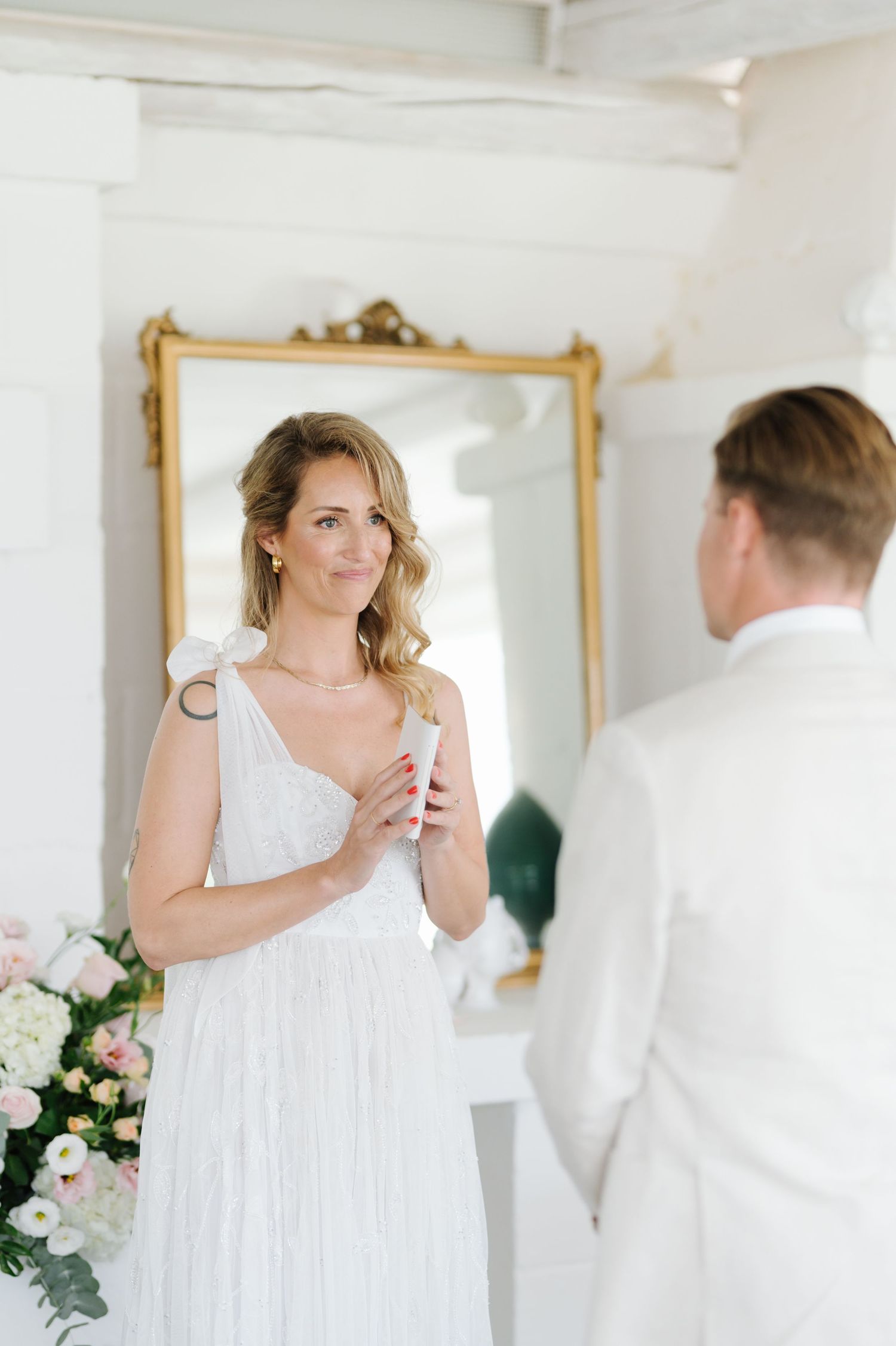 A bright white room with gold-framed mirrors serves as backdrop for a special moment.