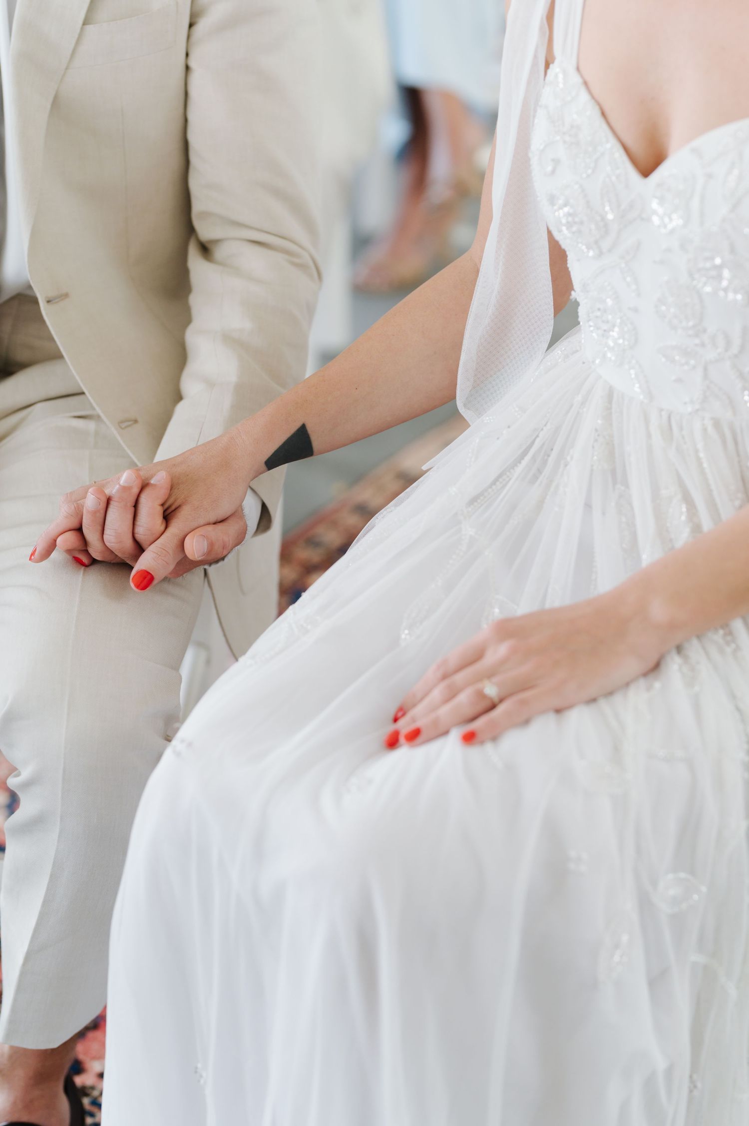 Close-up of hands smoothing white fabric on a formal dress.