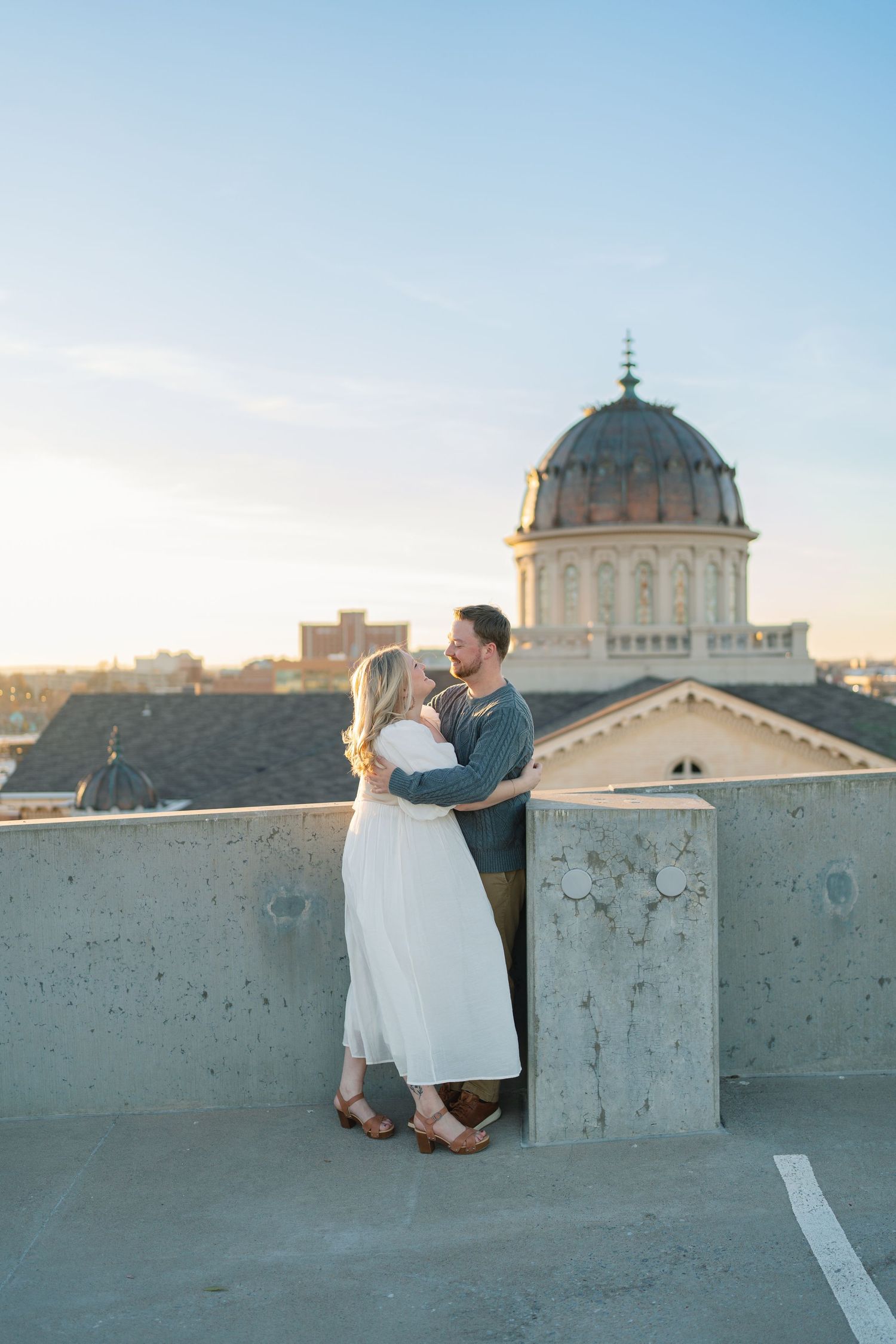 Romantic rooftop moment with domed building visible in background.