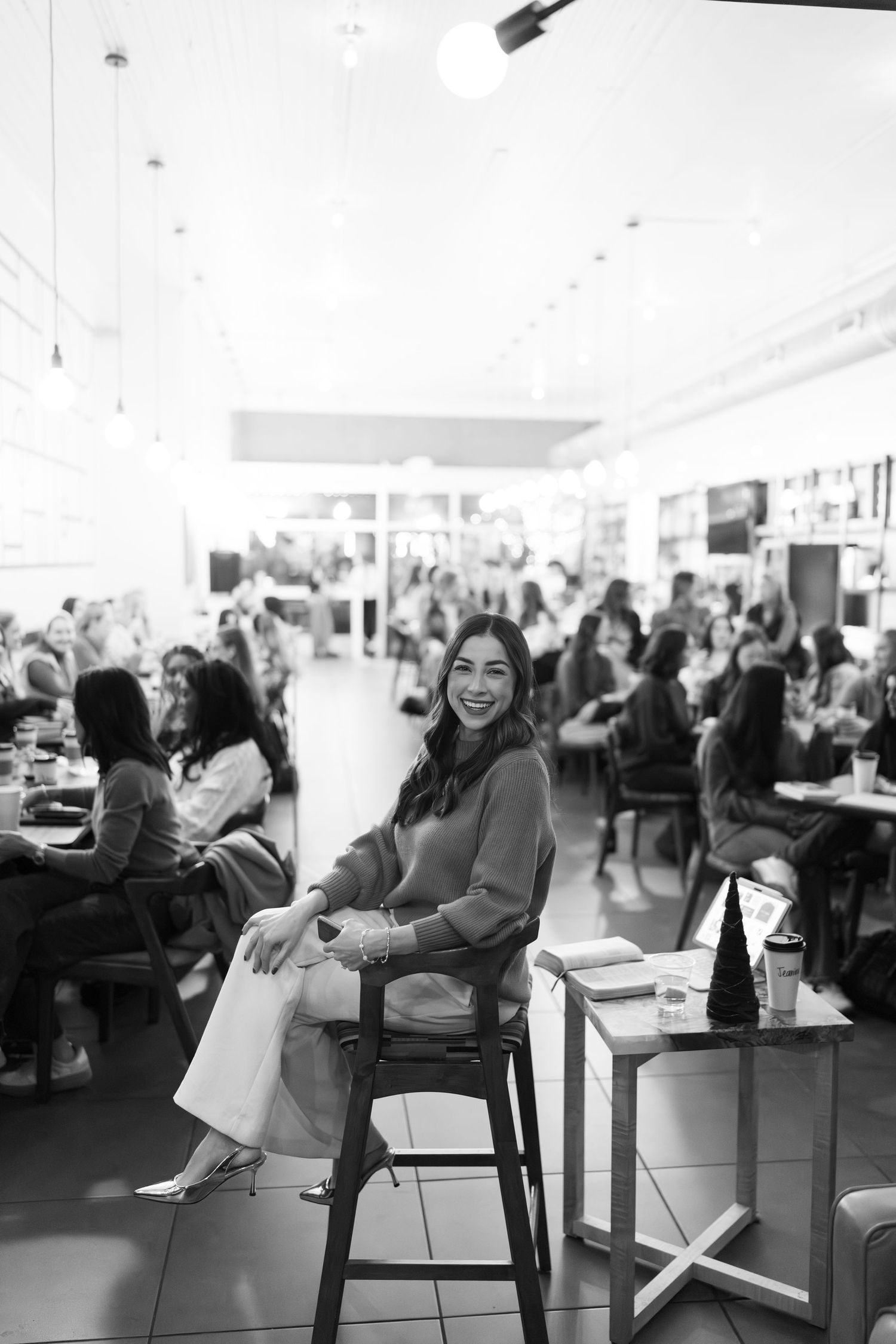 A series of black and white photos showing people sitting and laughing in a casual office or meeting space.