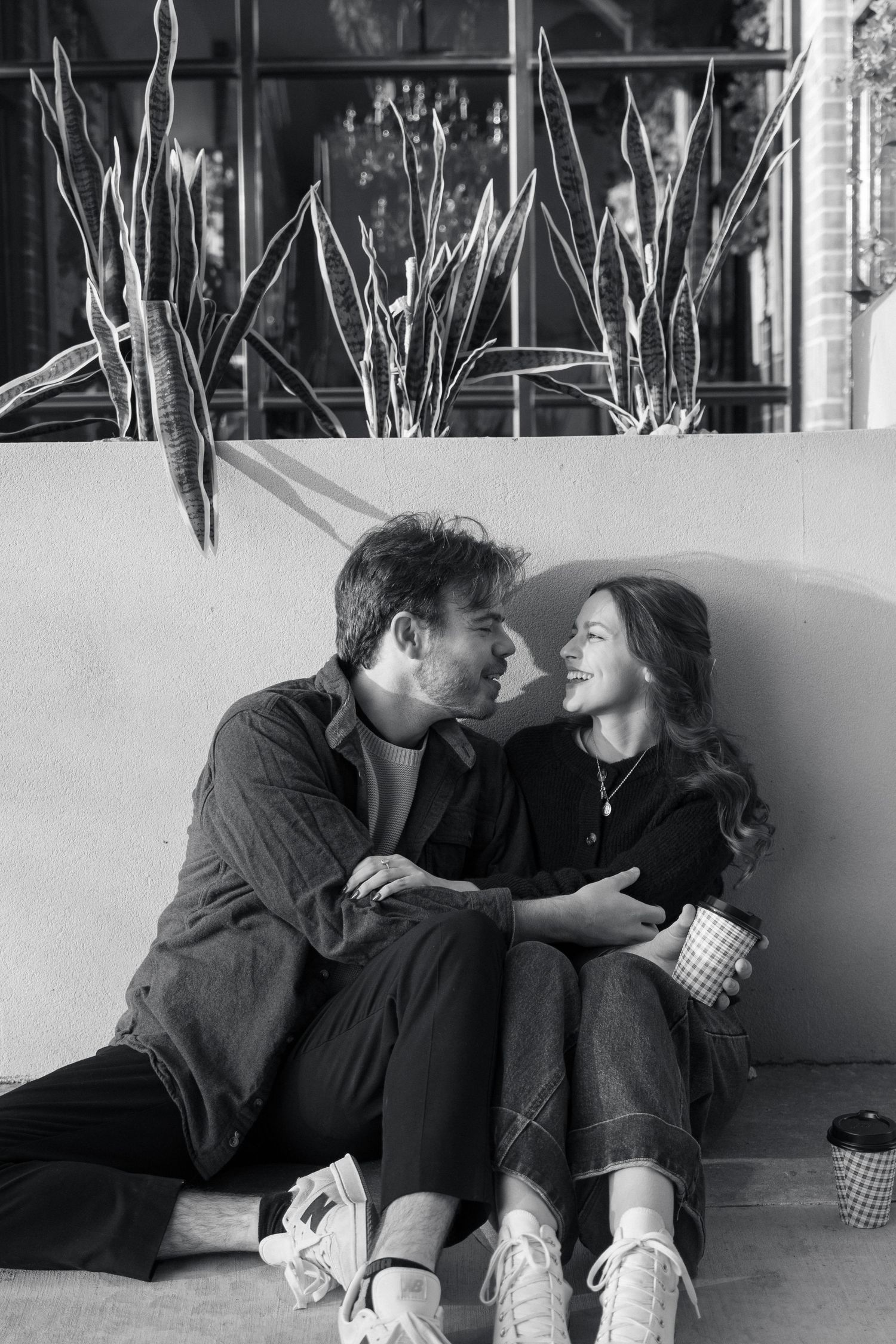 Black and white sequence of couple relaxing together on floor.