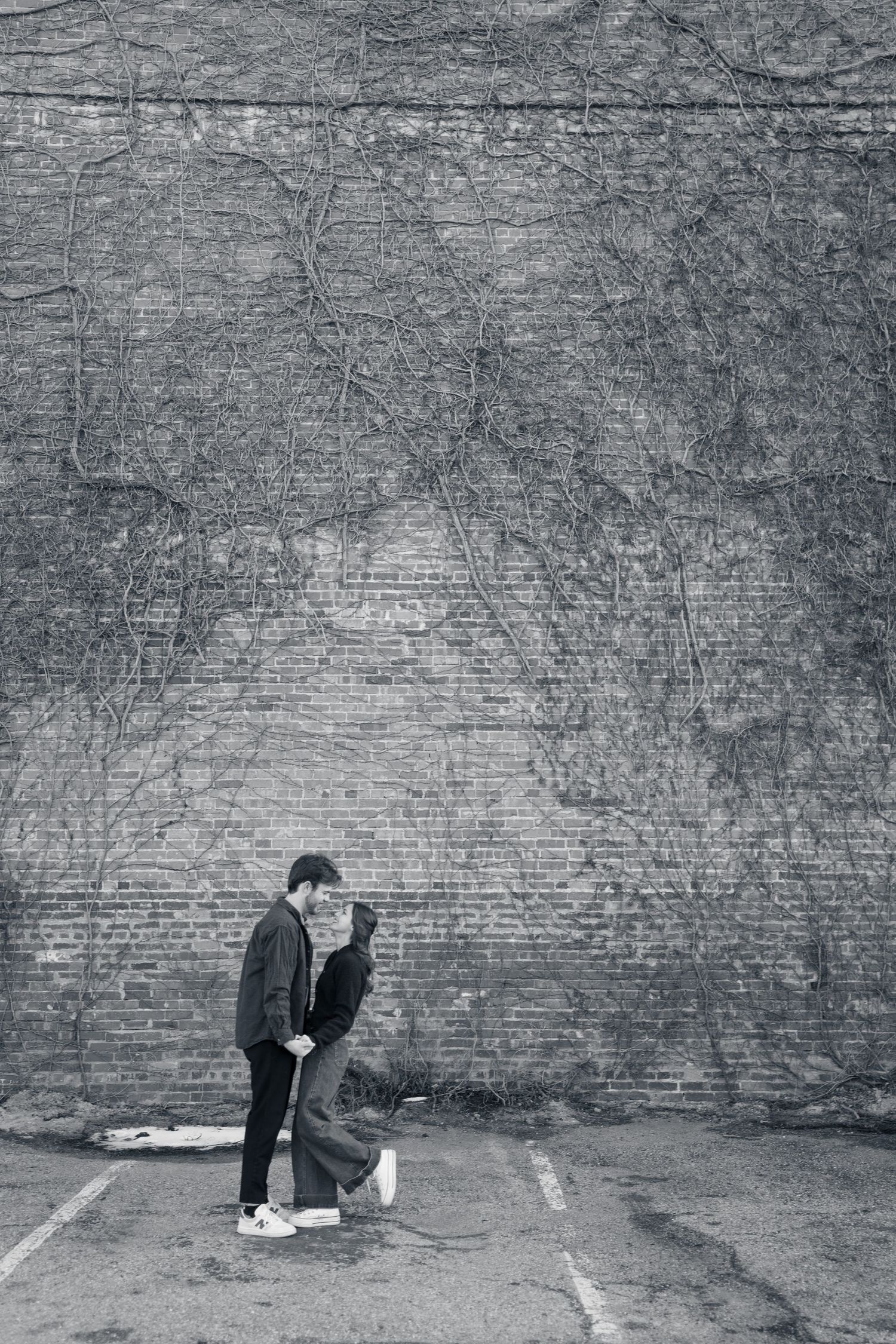 Artistic black and white sequence showing figure crouching against brick wall.