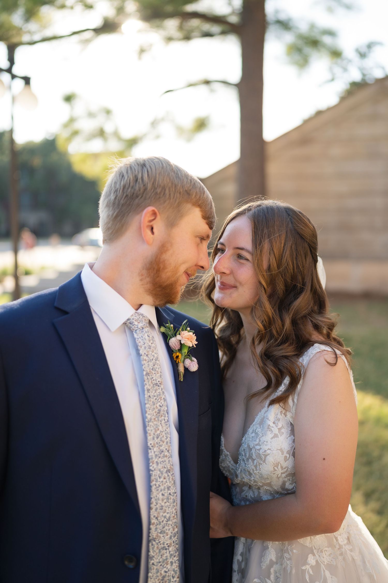 Romantic sunset wedding portraits captured against a rustic stone wall backdrop.