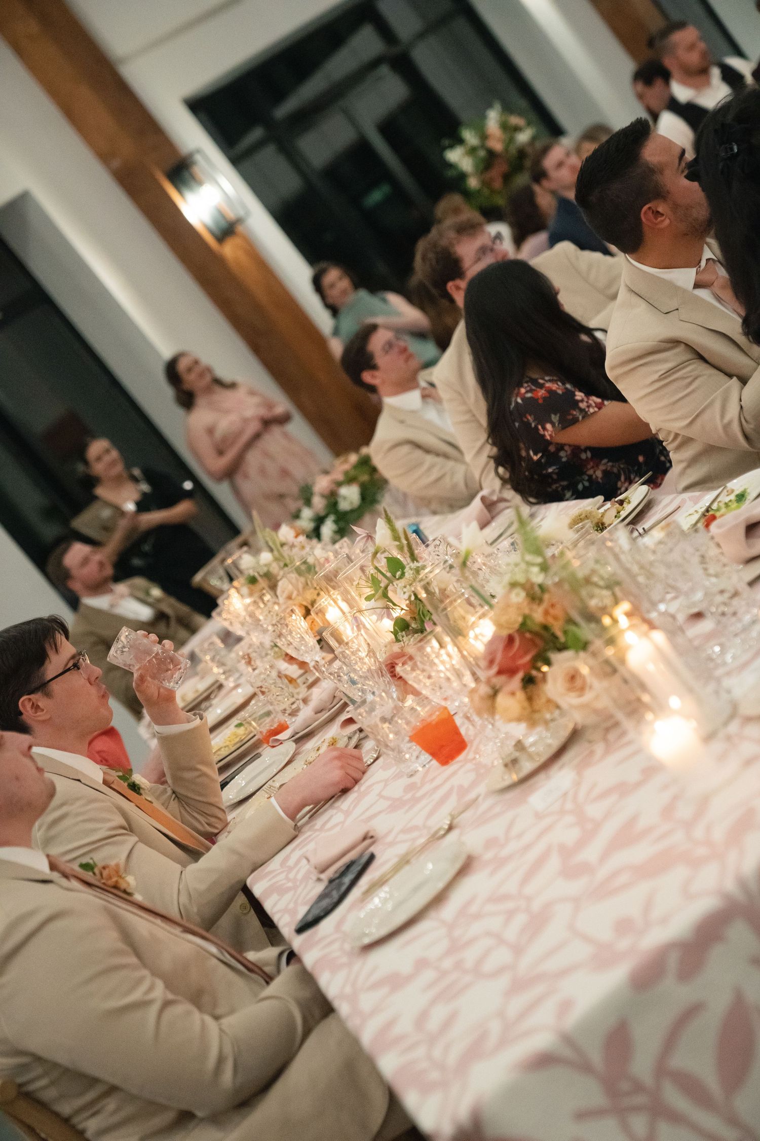 Wedding reception dinner table decorated with candlelight and floral centerpieces.
