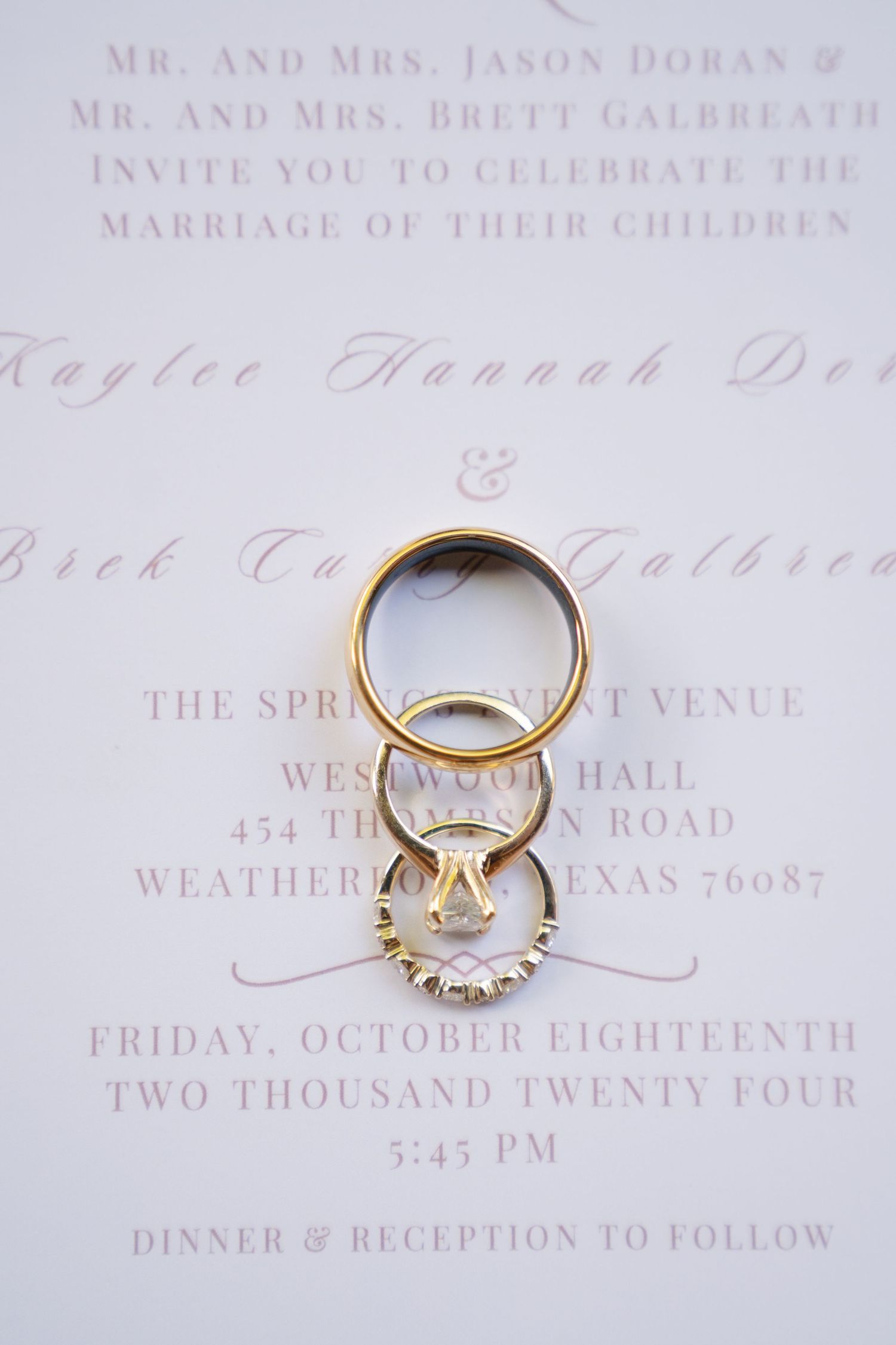 Wedding rings arranged artistically on an elegant wedding invitation.