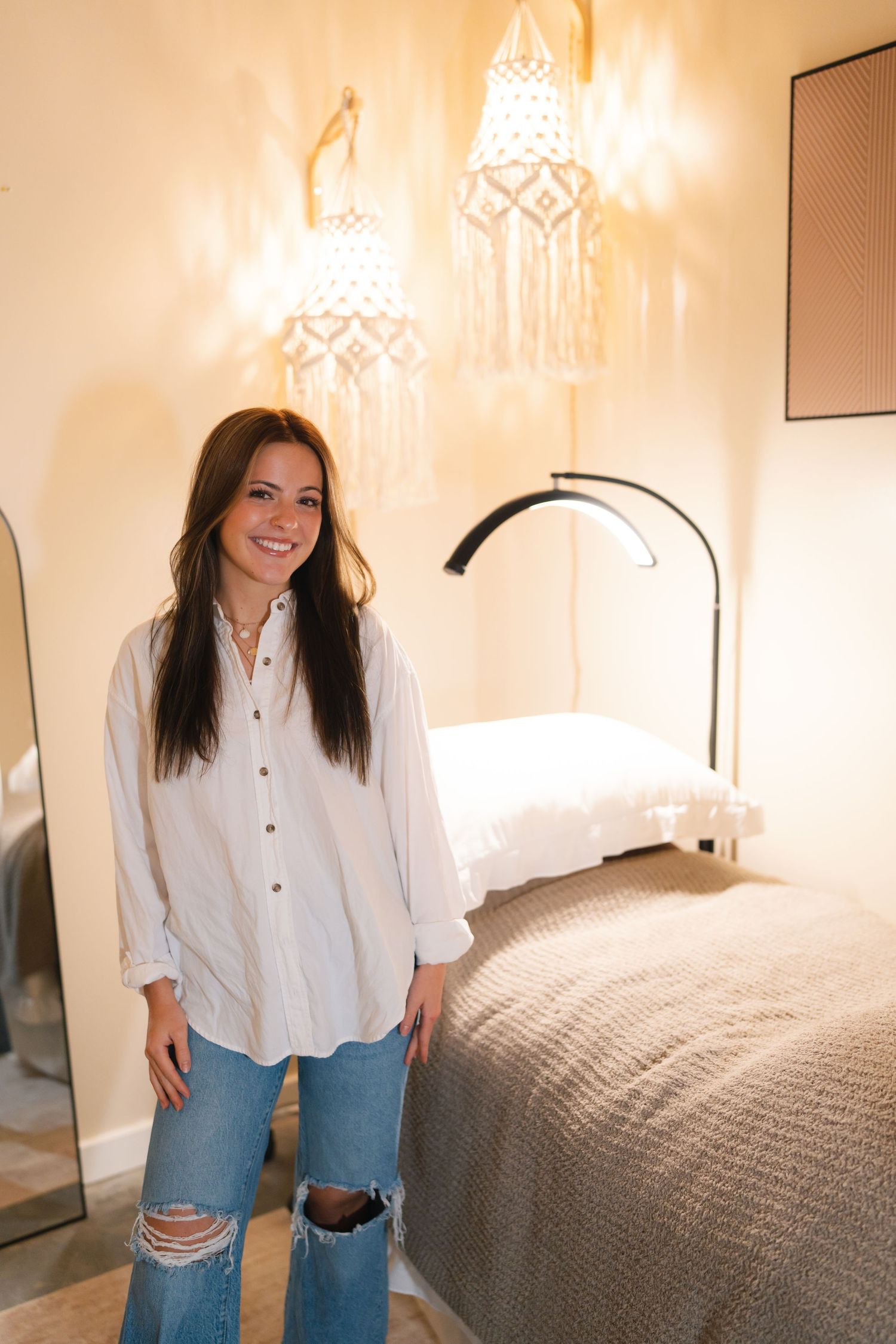 A series of four photos showing someone in a white button-down shirt and jeans posing in a cozy bedroom setting.