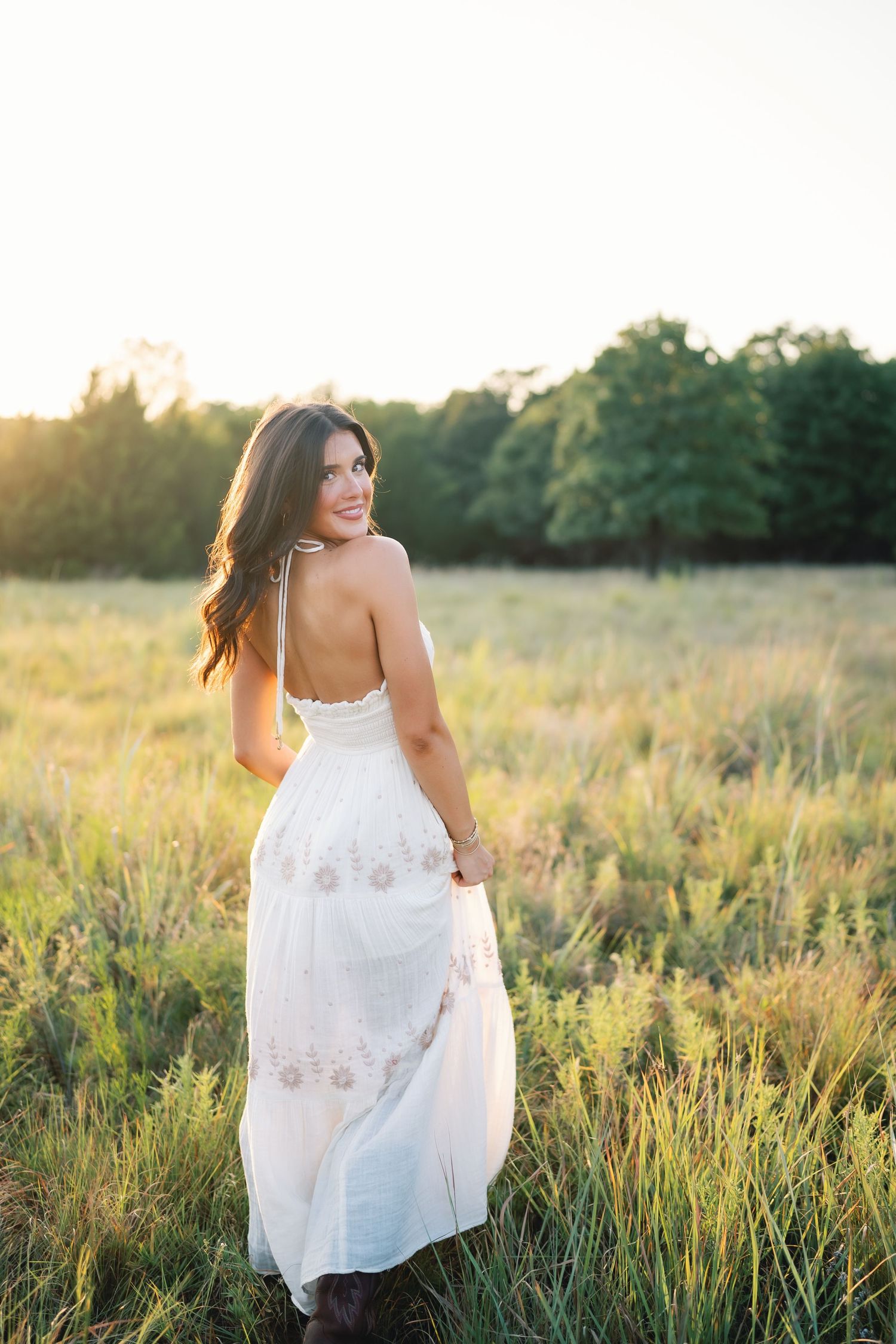 Dreamy portraits in a white dress among tall grass at golden hour.