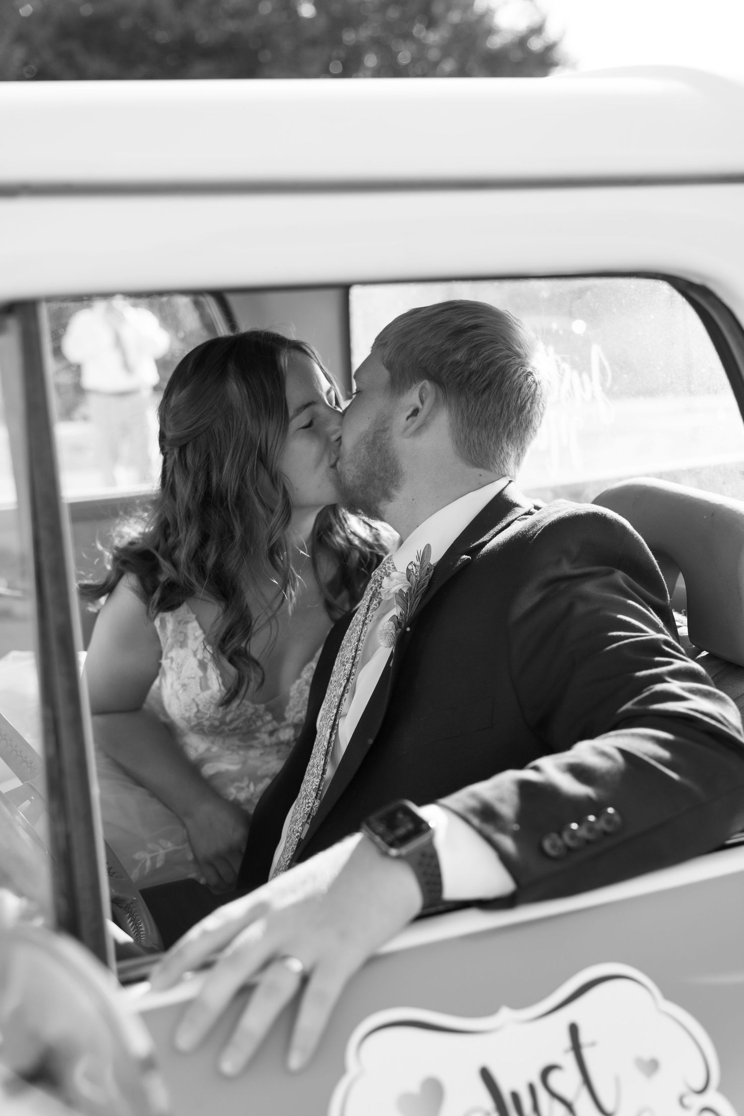Romantic wedding car photos showing tender moments through the vehicle windows.