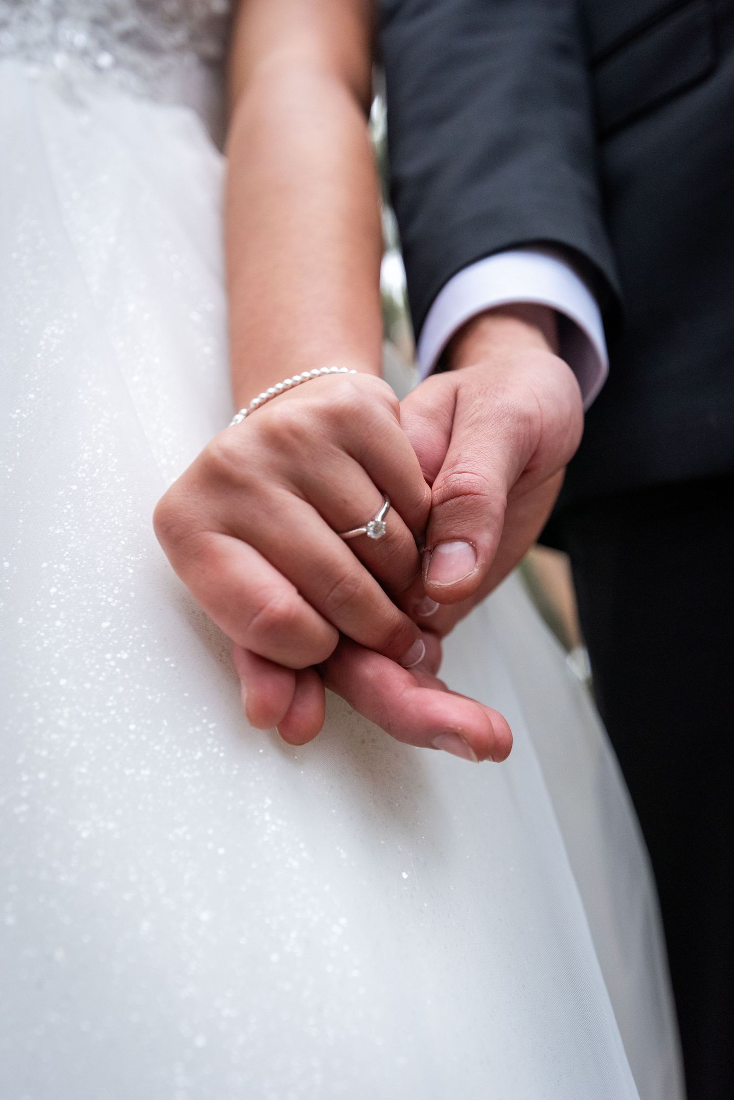 Close-up view of wedding rings being exchanged during a ceremony.
