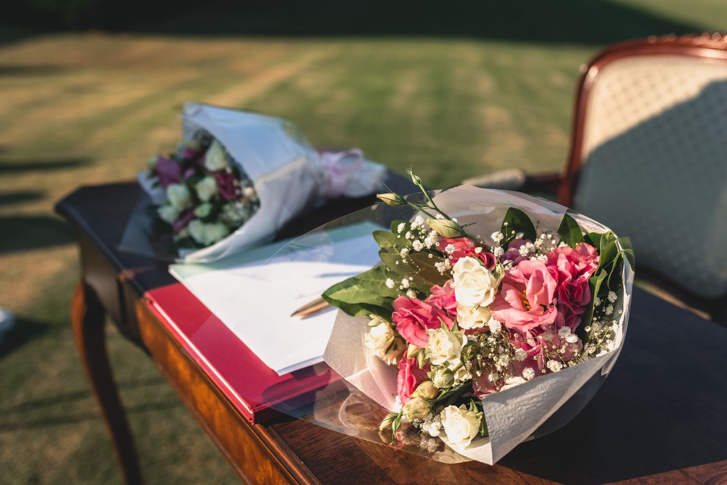 A collection of elegant floral bouquets and arrangements displayed at an outdoor wedding ceremony setup.