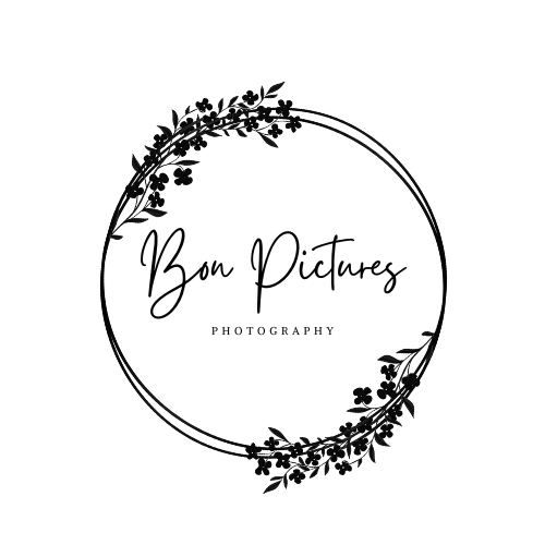 Black circular frame with delicate floral laurel design on dark background.