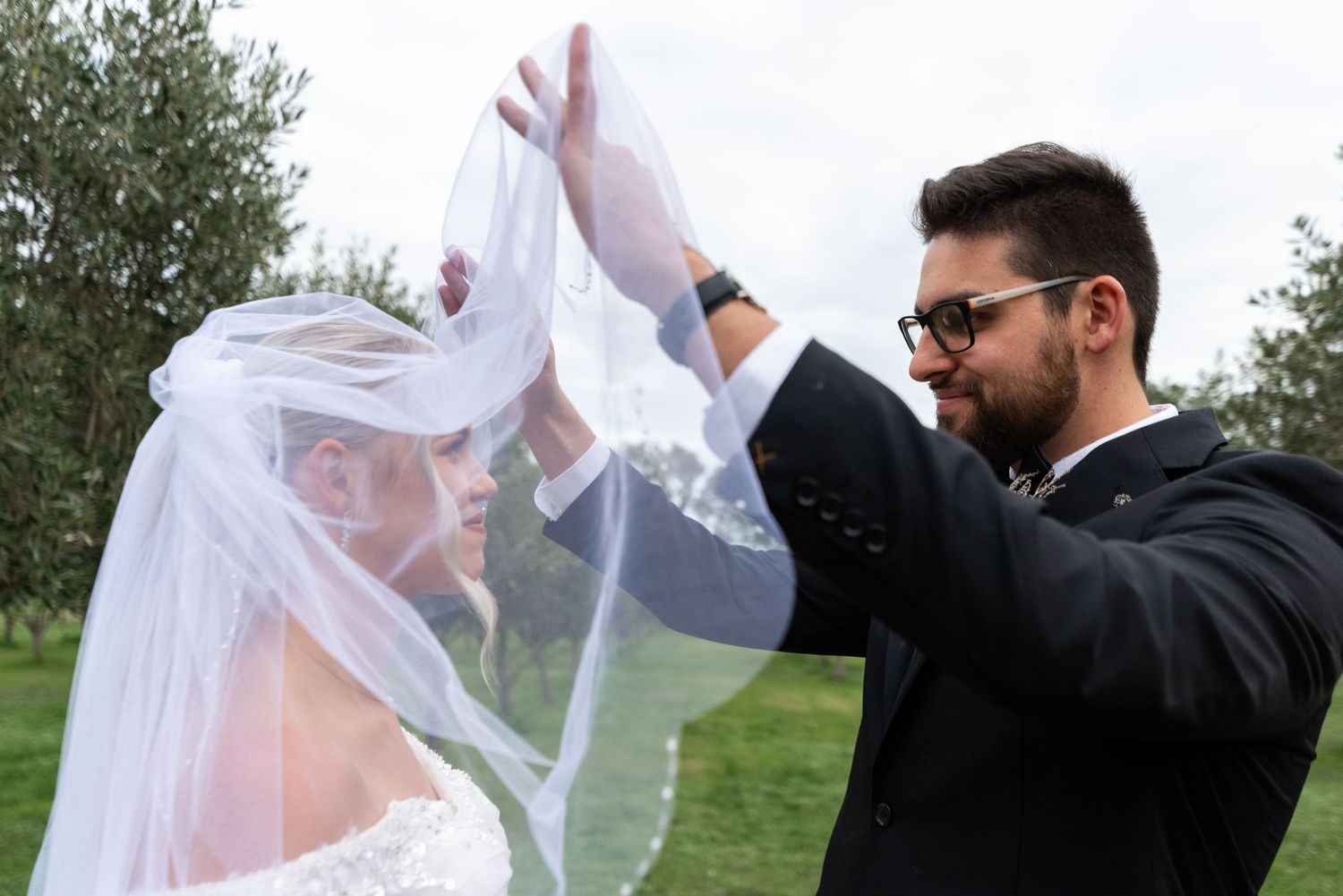 Wedding celebration with dancing and veil movement captured in outdoor garden setting.