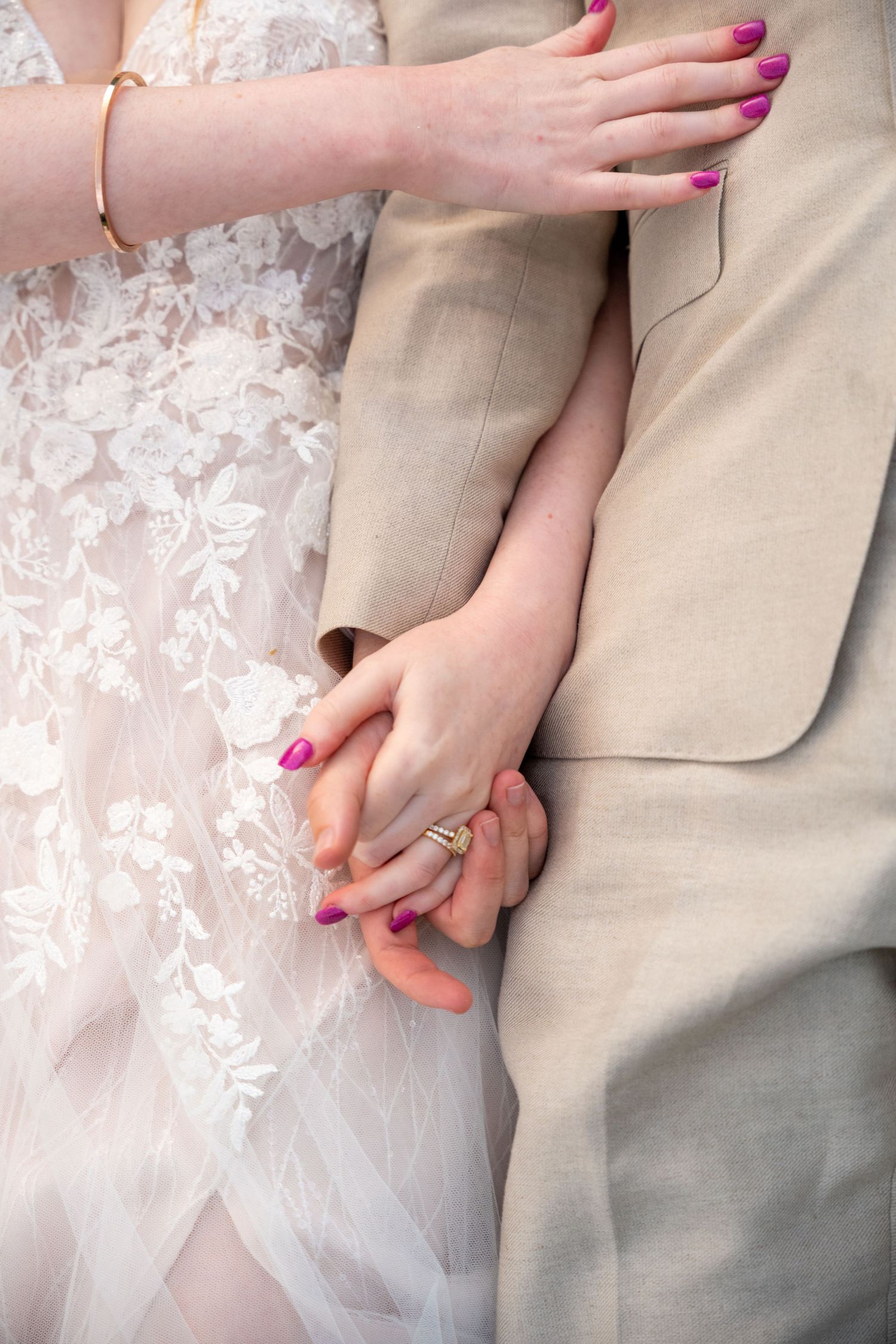 Close-up shots of a couple holding hands, showing pink nail polish and wedding attire details.