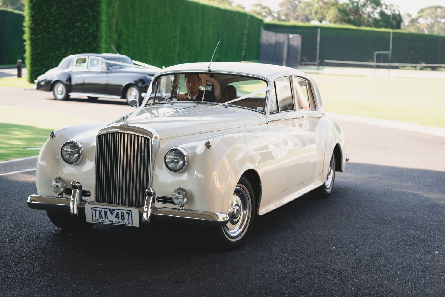 Vintage silver Bentley luxury car photographed from multiple angles showing its classic elegant design and chrome details.