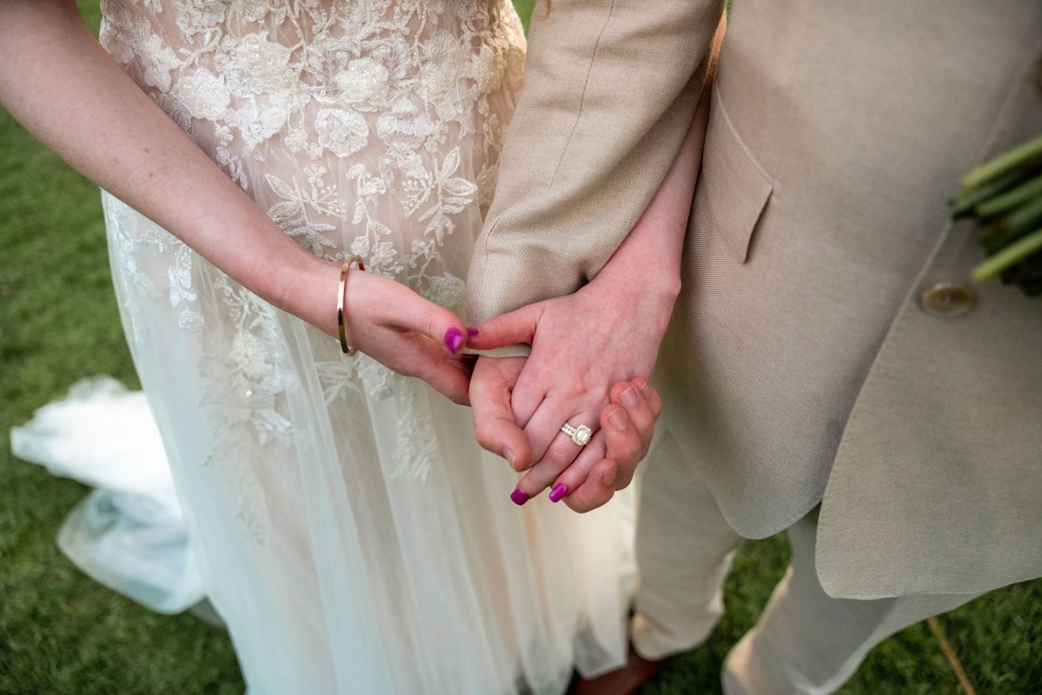 Close-up details of wedding attire showing lace dress and tan suit.