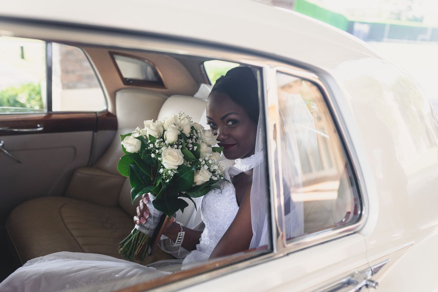 A series of four connected images showing a person sitting in the back seat of a car with floral decorations.