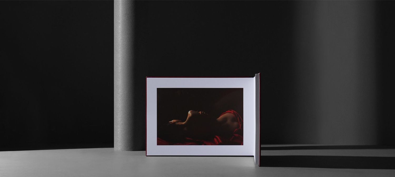 A series of framed artwork or photographs displayed in a gallery-style setting against a dark wall.