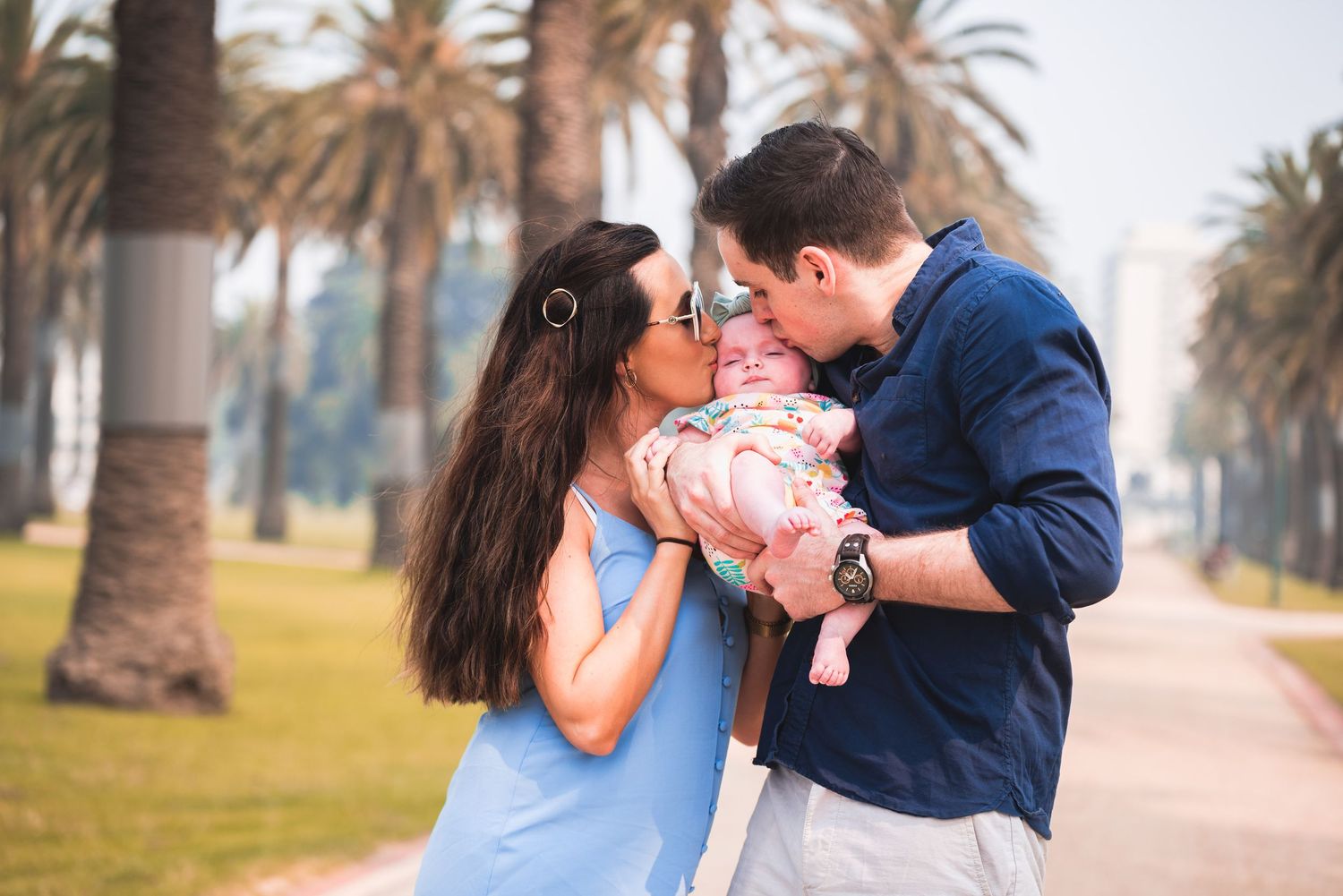 Romantic couple shares tender moments along a palm tree-lined path during their engagement photo session.