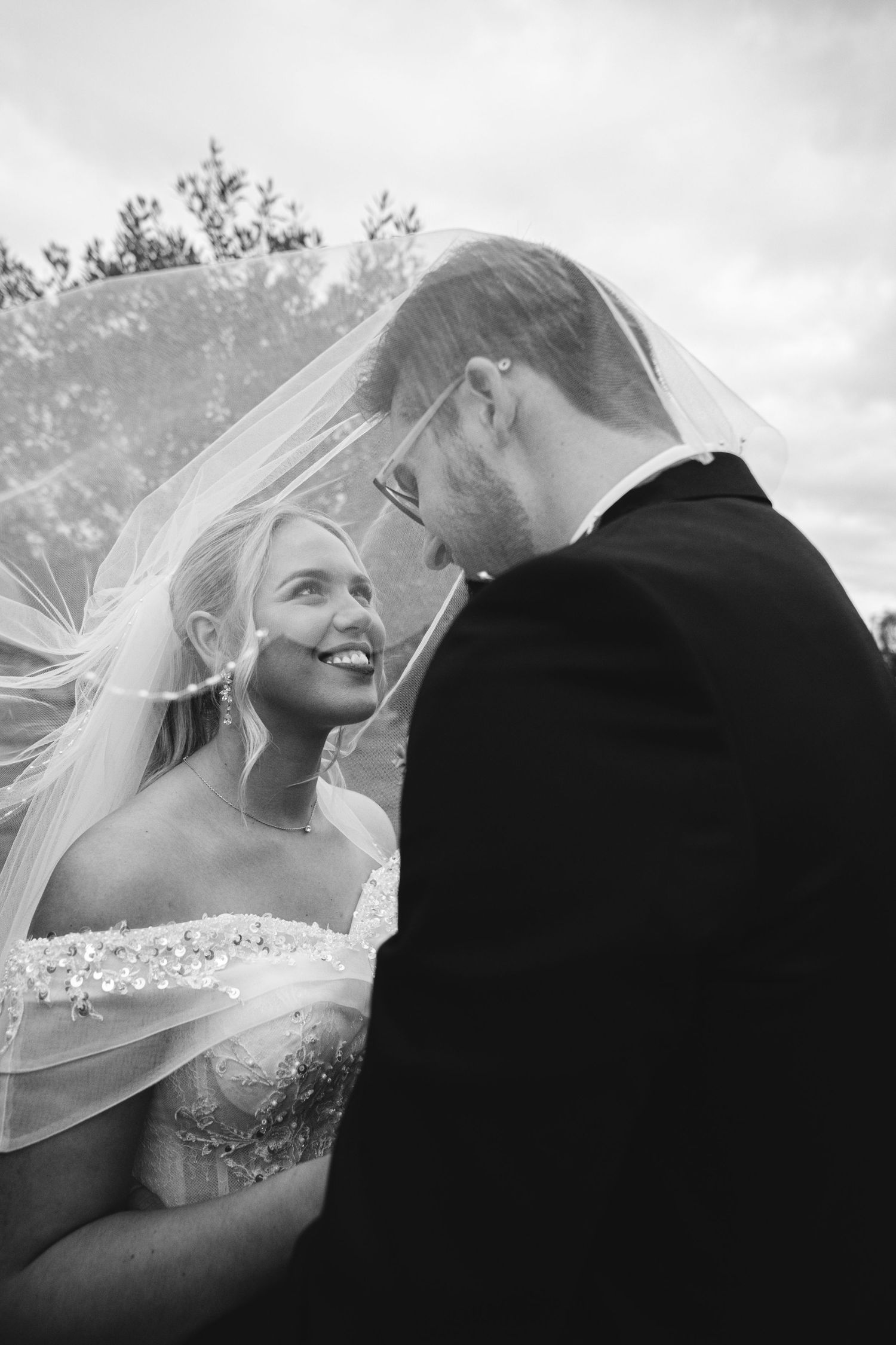 A romantic black and white wedding sequence showing tender moments between a bride and groom under a veil.