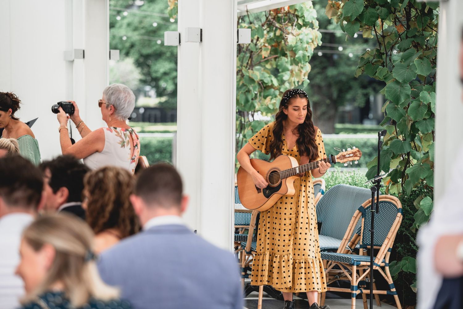 A series of candid wedding reception photos showing guests mingling and dancing in an outdoor venue with string lights.