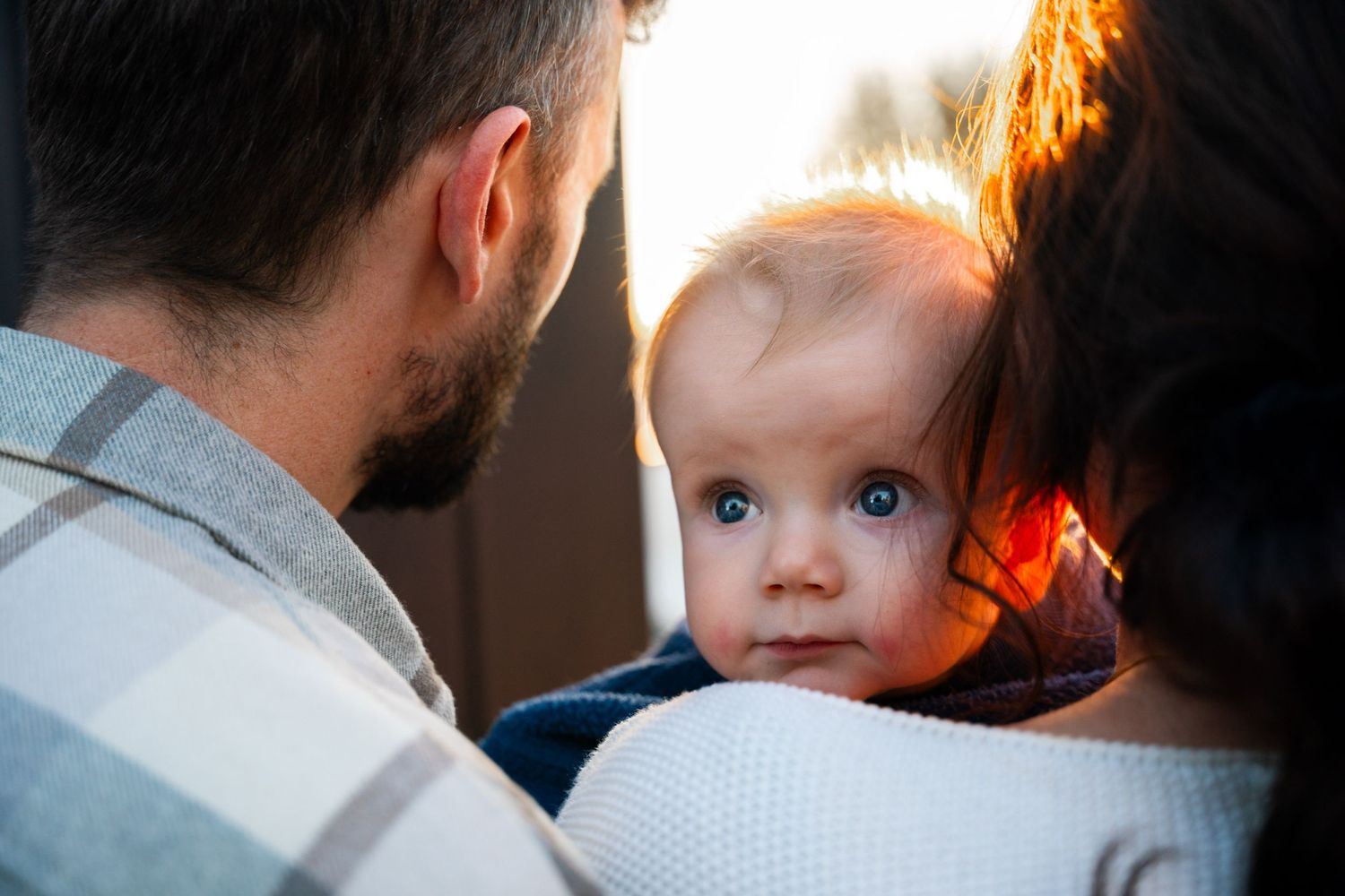 Close-up of parents and baby sharing an intimate moment at home.