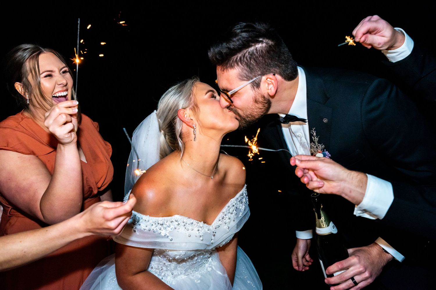 A romantic wedding couple shares a playful moment during their first dance at an evening reception.