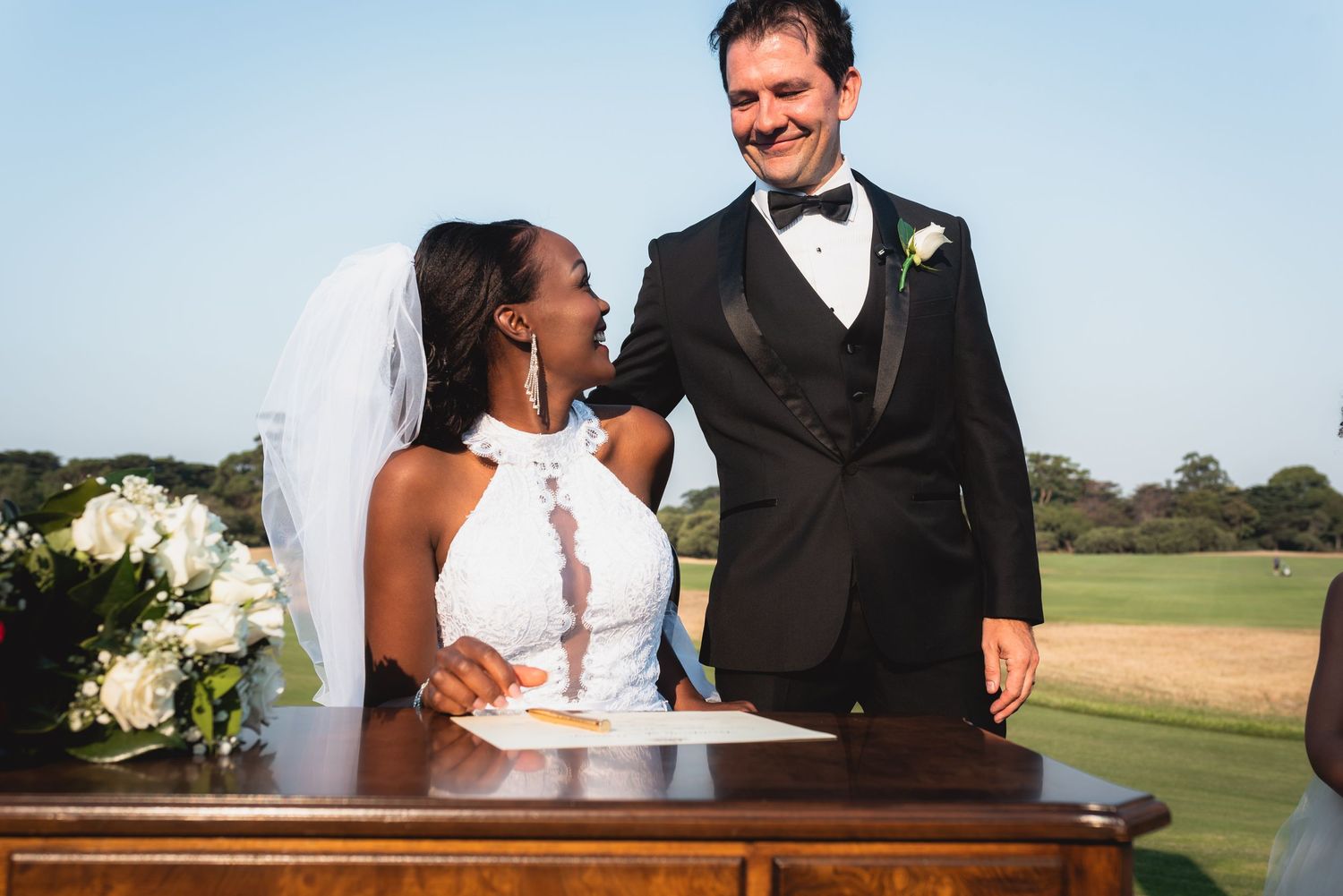 A happy couple in wedding attire share joyful moments together in an outdoor setting during their special day.