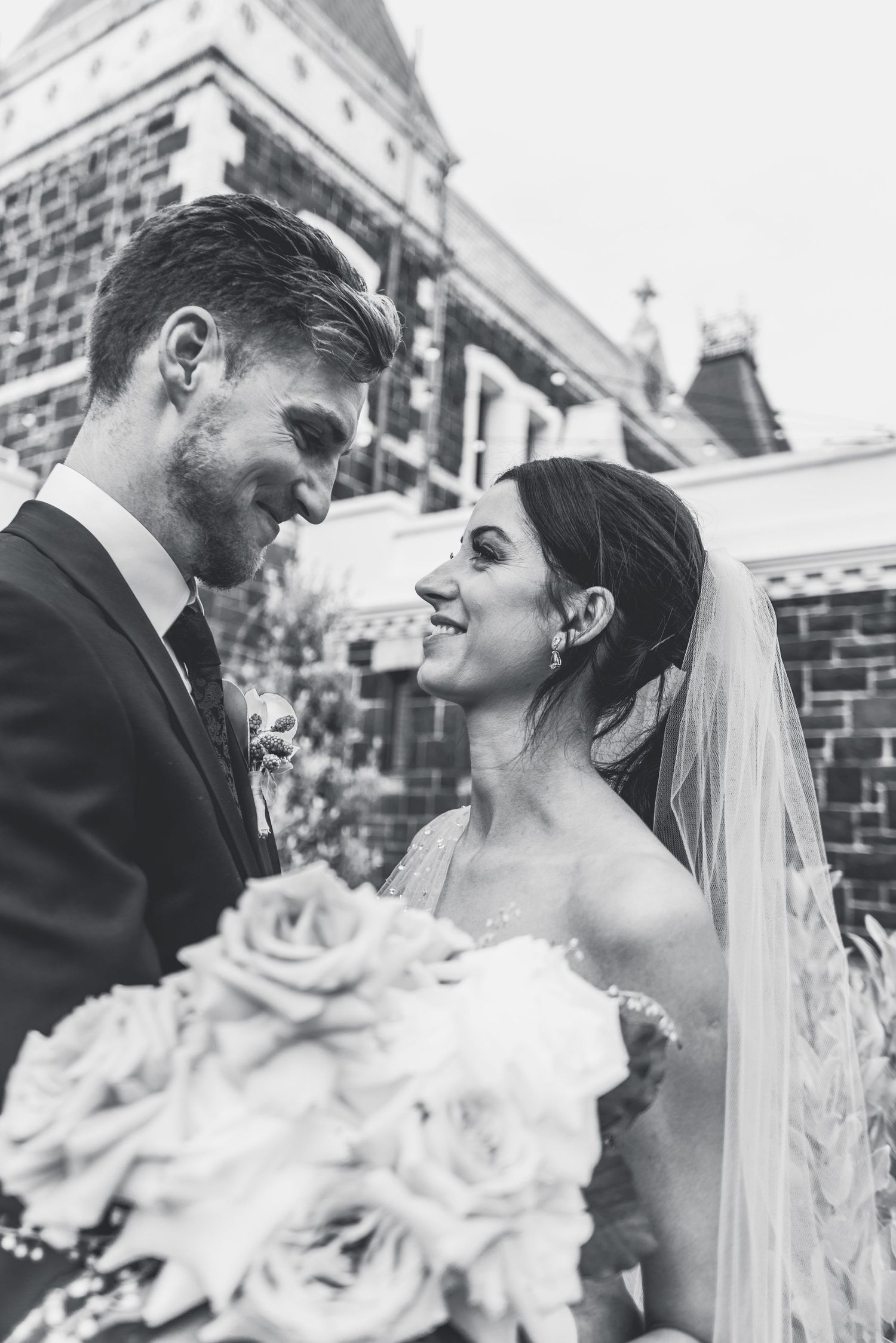 Black and white wedding photos show intimate moments between newlyweds with bride holding white floral bouquet.