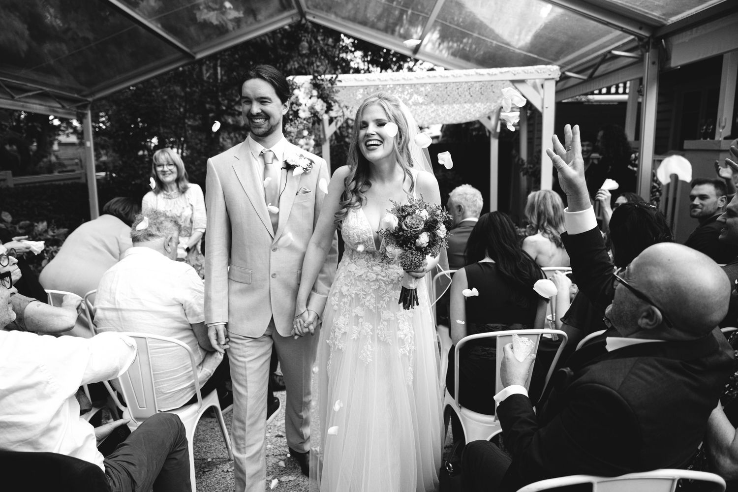 Wedding reception celebration under a white tent with dancing and festivities.