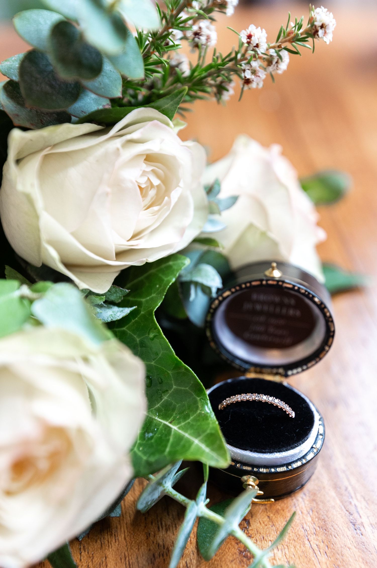White roses and Oreo cookies arranged together as decorative wedding details on a wooden surface.