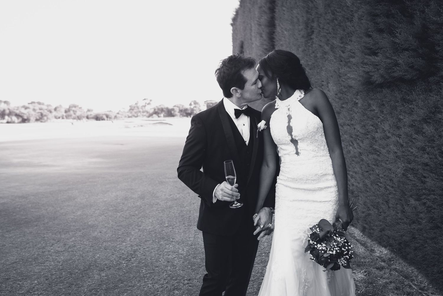 A black and white wedding photo collage showing romantic moments between newlyweds in various outdoor settings.