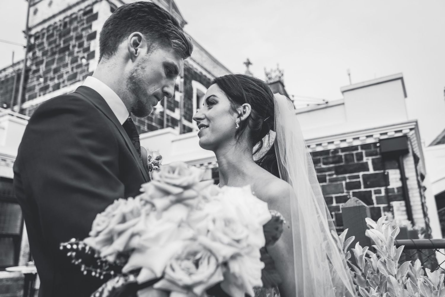 Black and white wedding photos show romantic moments between newlyweds during their outdoor celebration.