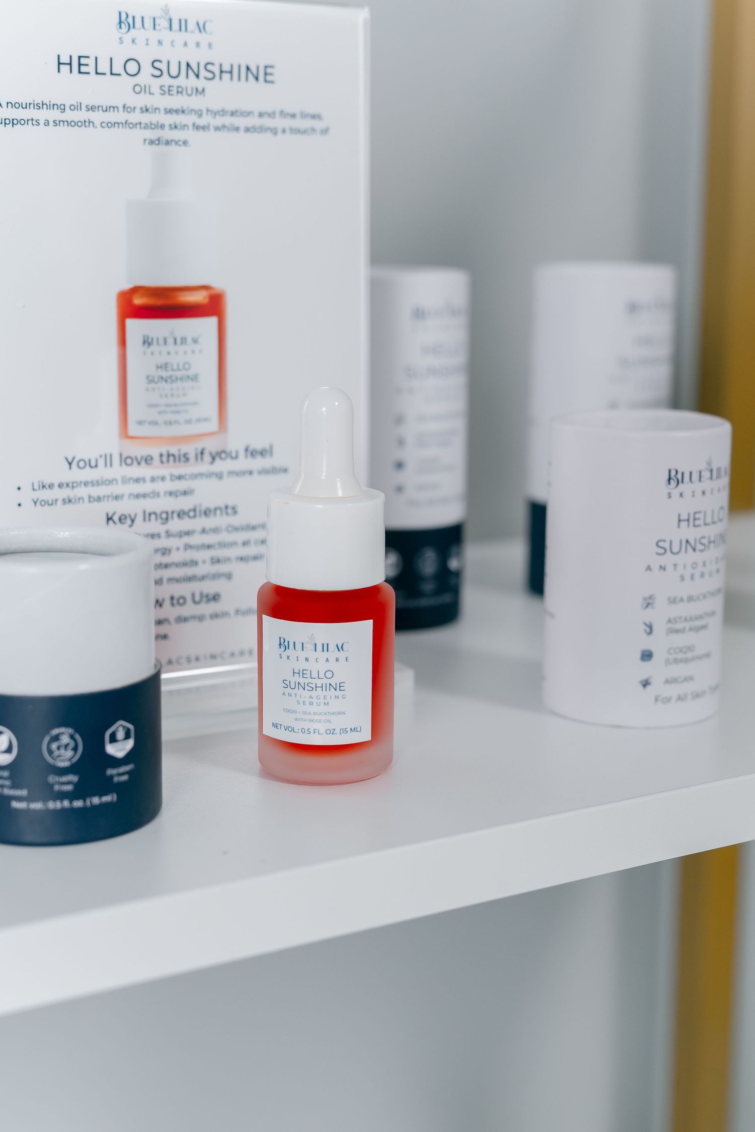 BluTru Skincare Hello Sunshine Oil Serum displayed on a white shelf with product box and dark blue moisturizer jar.