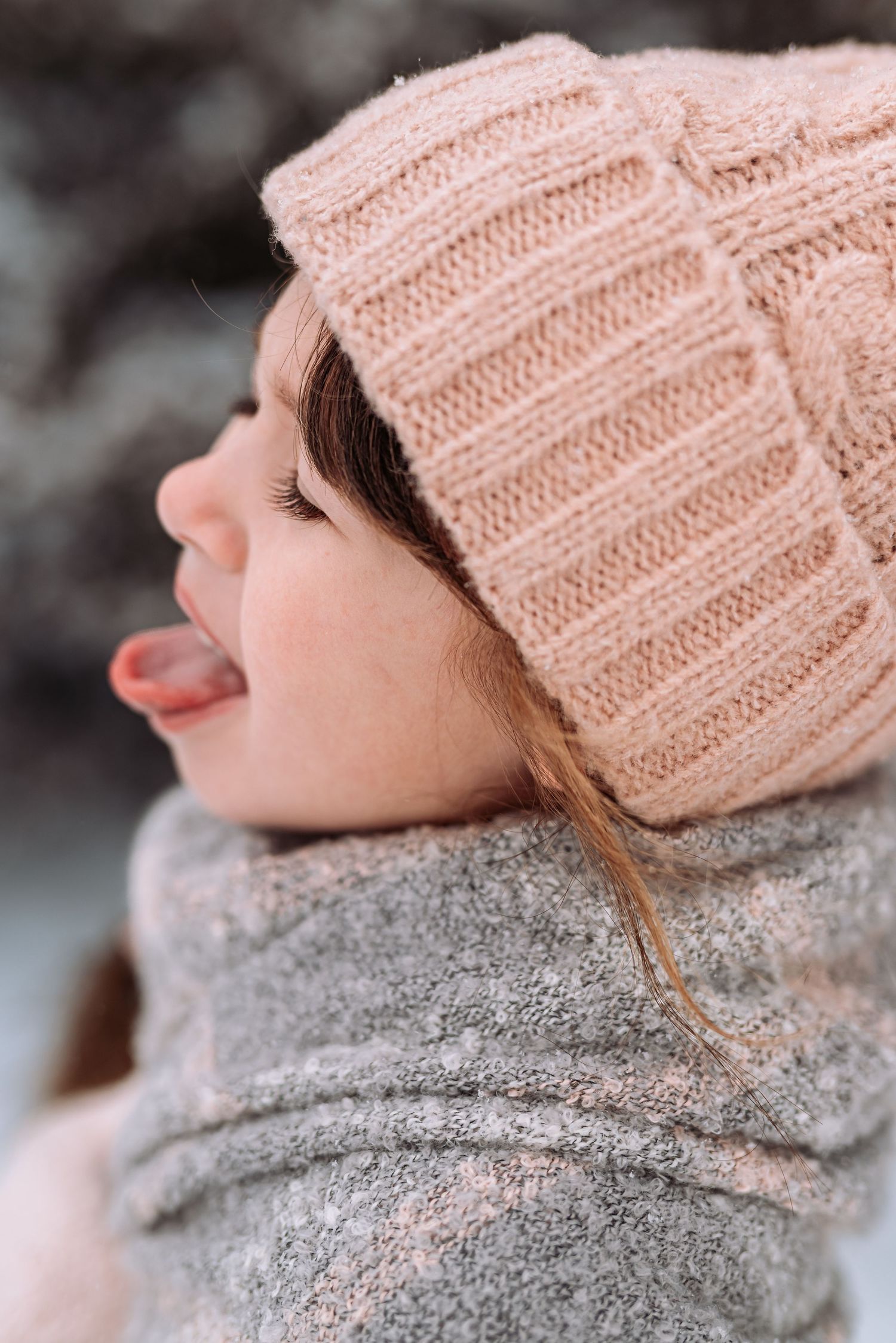 A person wearing a cozy pink knit beanie and gray sweater is shown in a series of close-up profile shots.
