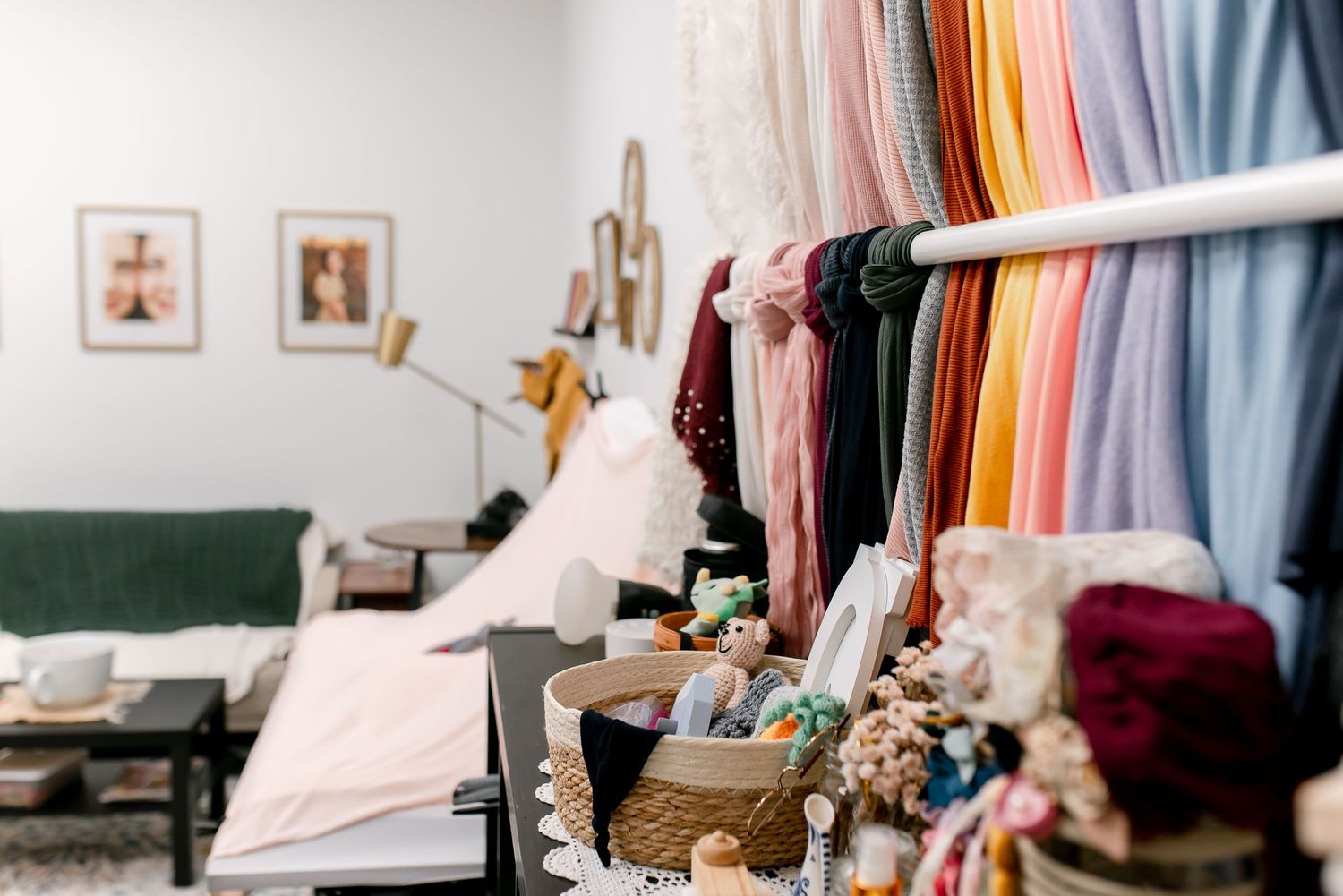 Colorful fabric swatches hanging on a rack in a bright bridal boutique with a cozy seating area in the background.